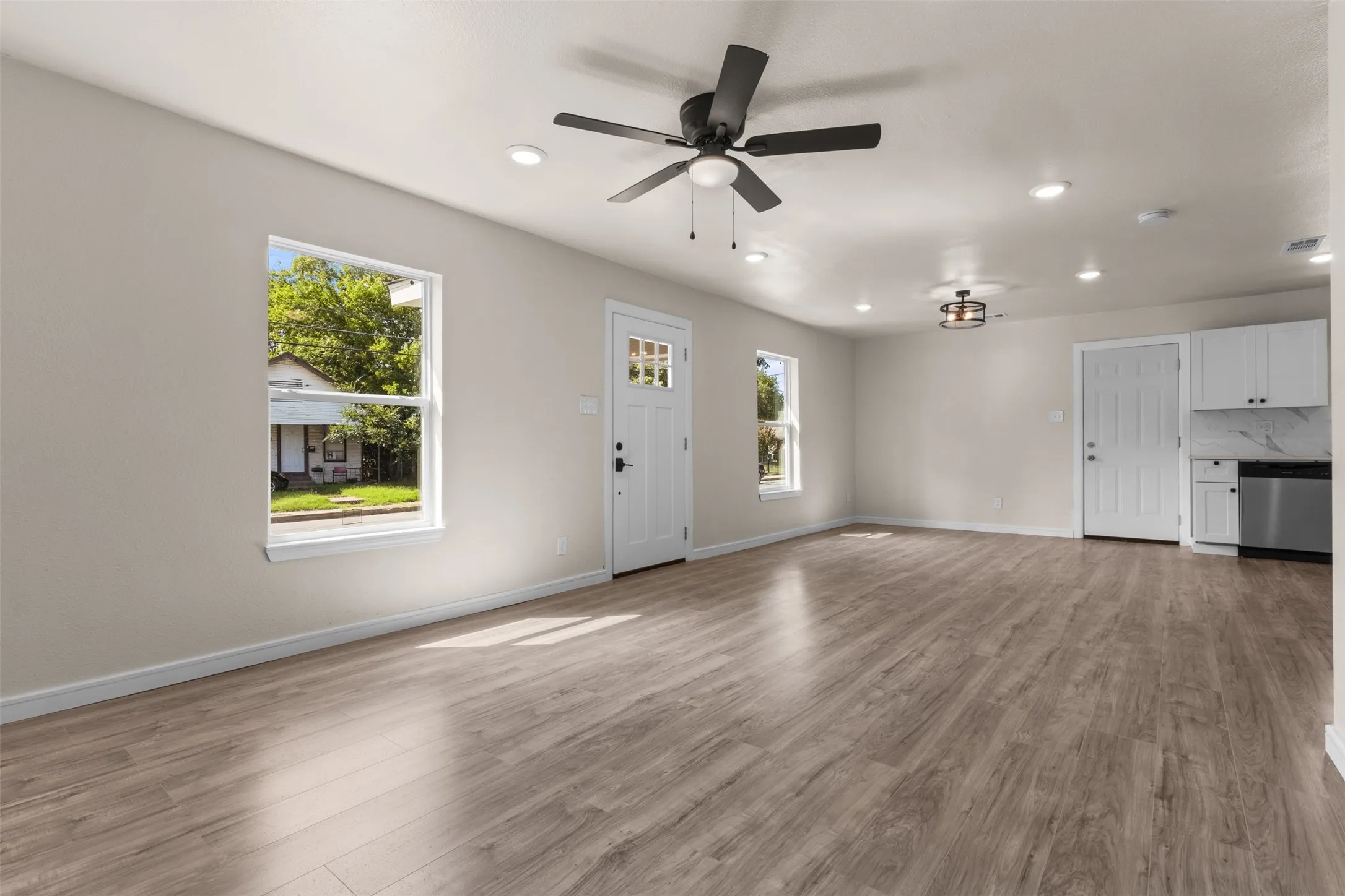 Open-concept living area featuring wood-finish flooring, recessed lighting, and a ceiling fan