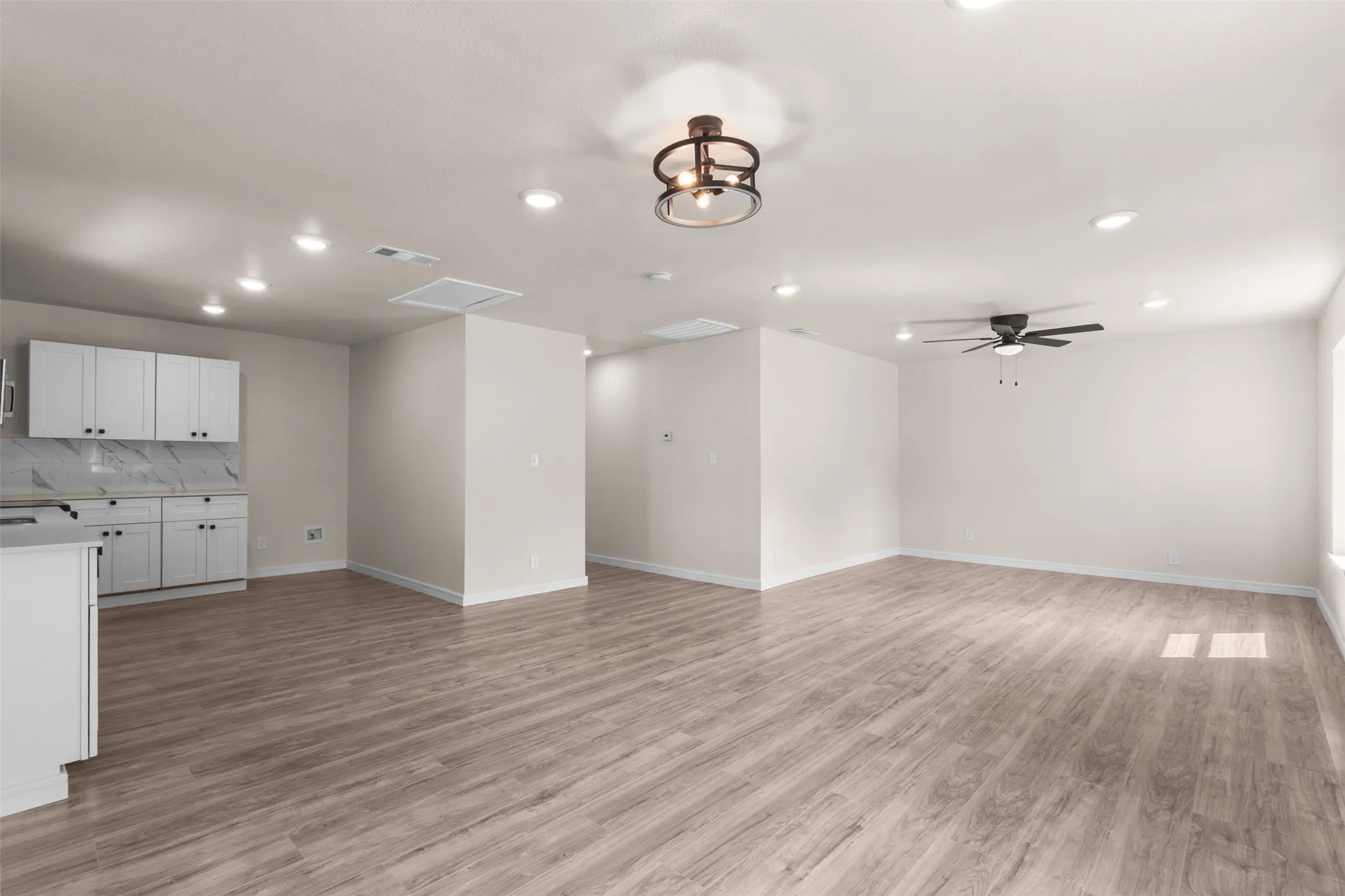 Spacious interior featuring wood-finish flooring, recessed lighting, and a ceiling fan