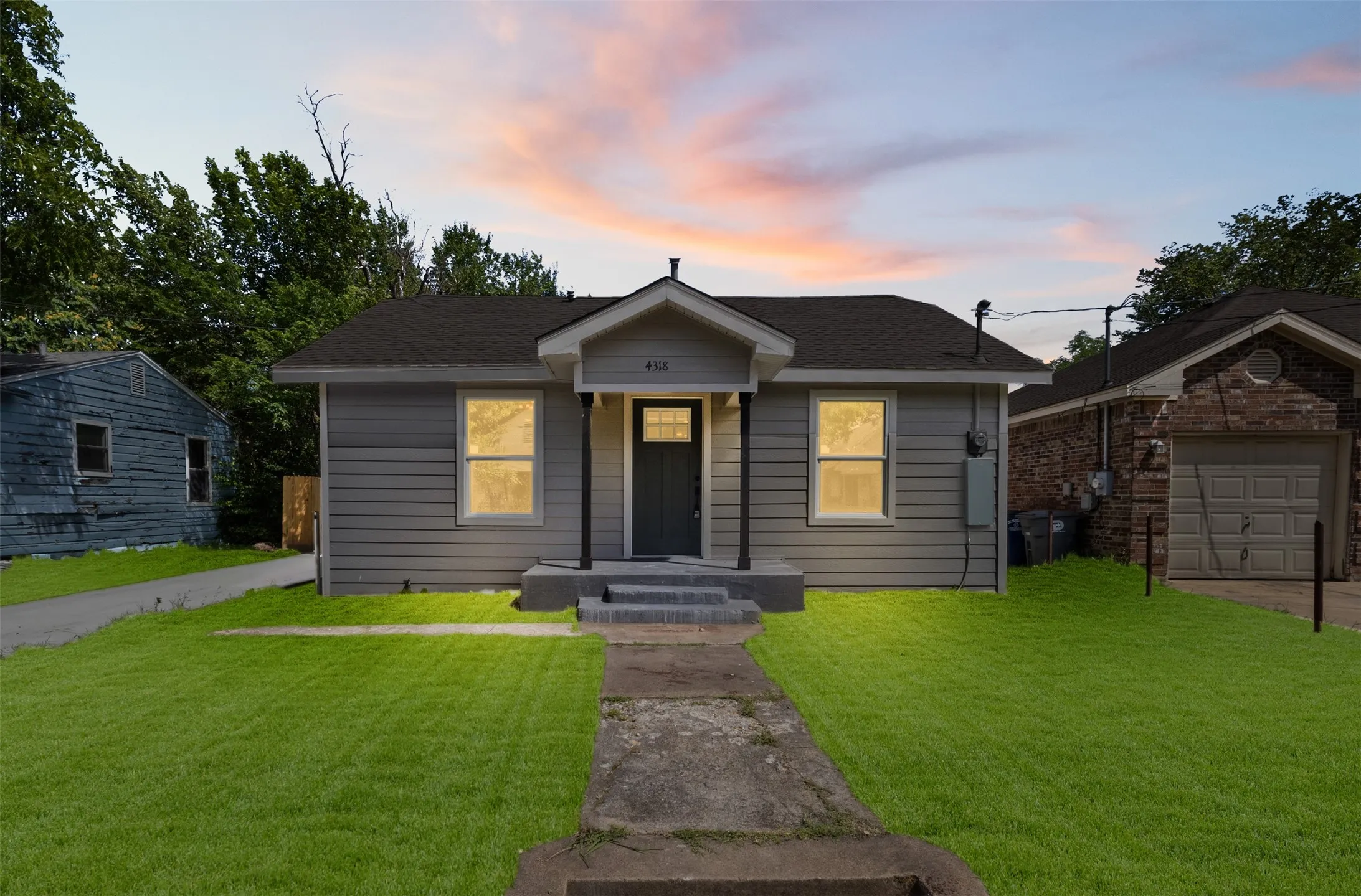 Single-story residence featuring light gray siding, a dark gray front door, and a covered entryway