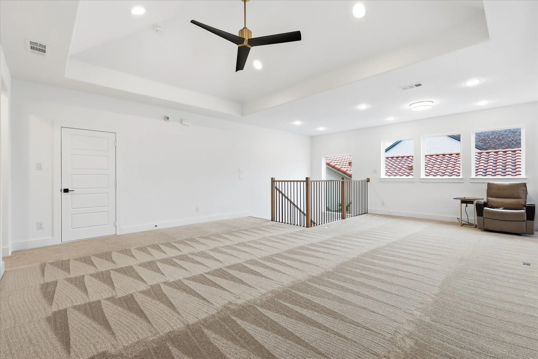 Spacious room featuring vaulted ceilings with a contemporary ceiling fan, recessed lighting, and large windows