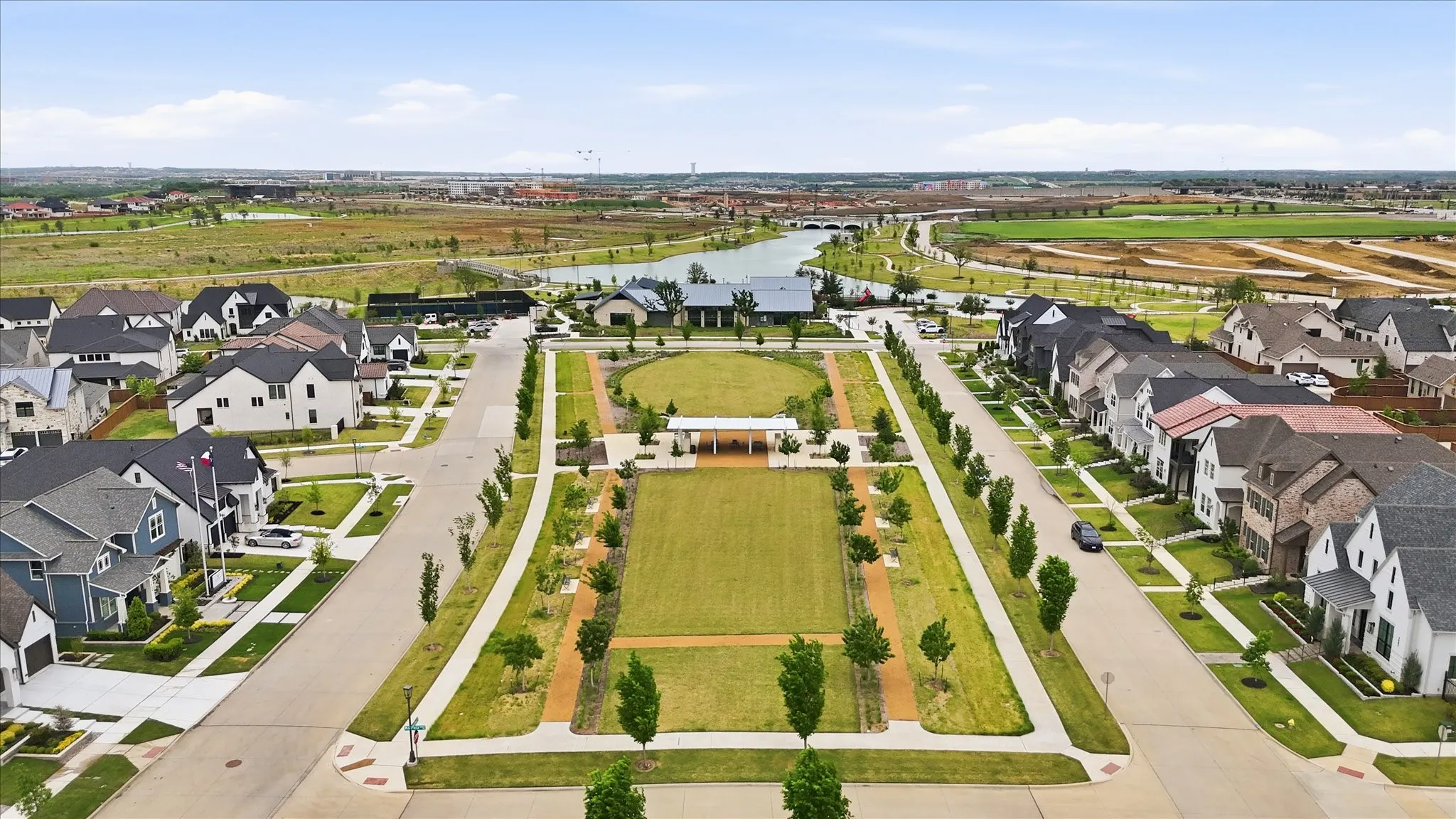 Aerial perspective showcasing a community park with a large central green space and a smaller circular lawn area