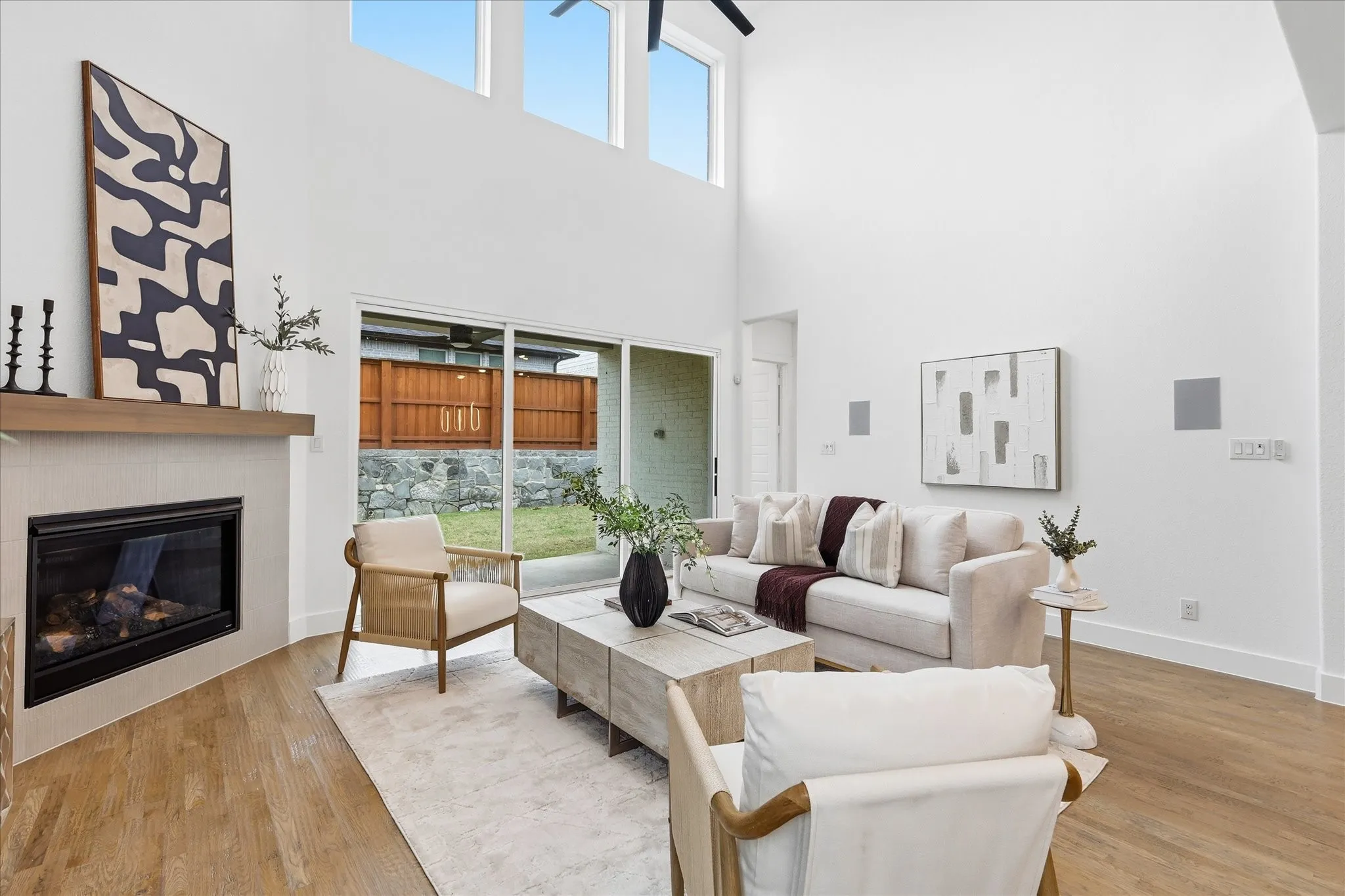 Spacious living area featuring a fireplace with a light-toned tile surround and wood mantel