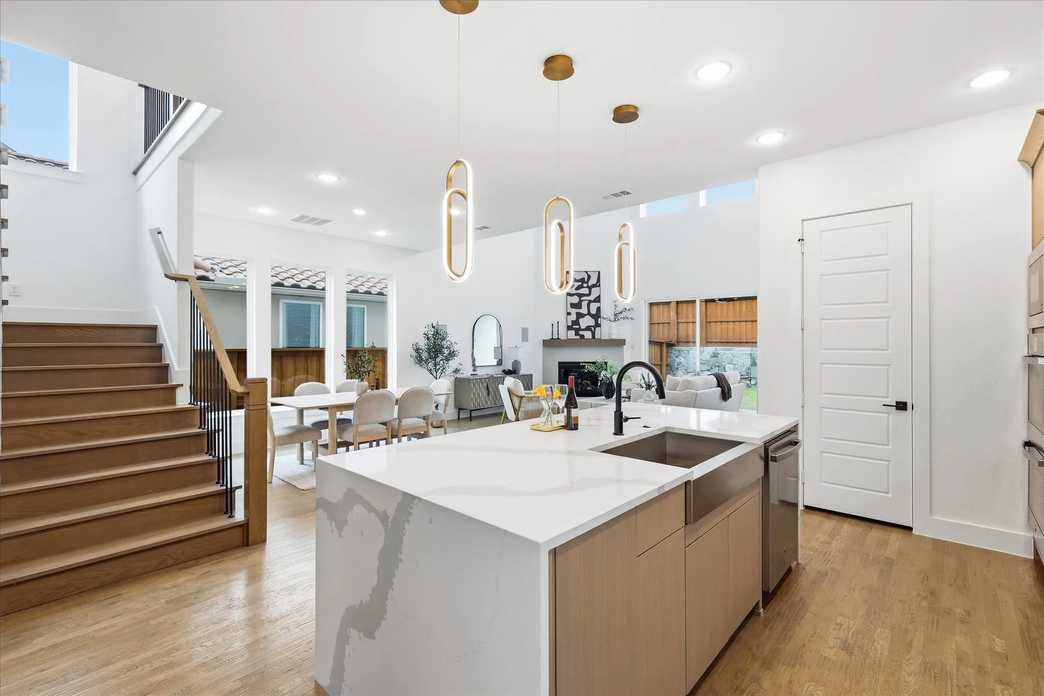 Gourmet kitchen island with a waterfall-edge countertop, undermount sink, and matte black faucet