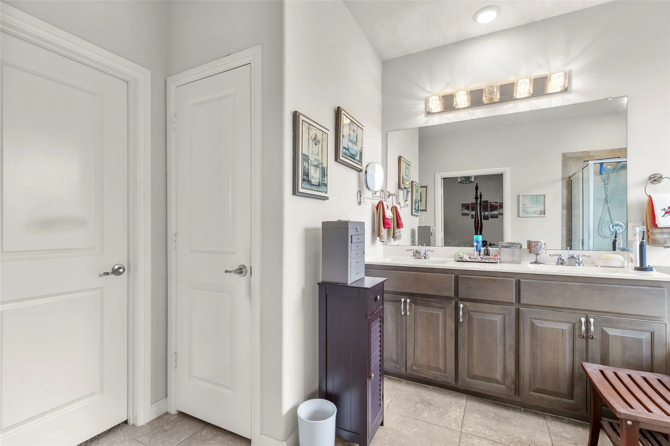Bathroom featuring a dual vanity with a light countertop, integrated sinks, and brushed nickel faucets