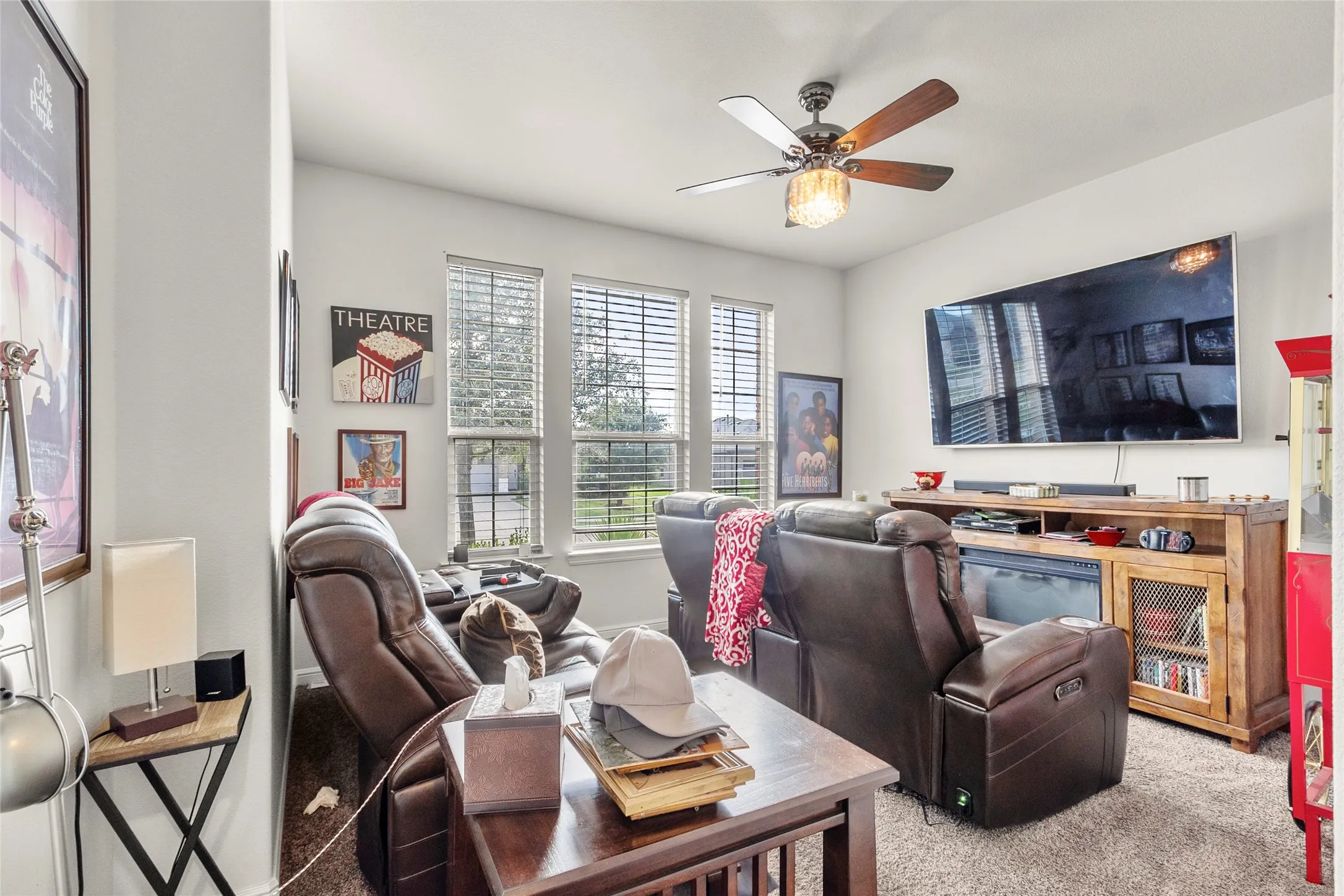 Carpeted living space with multiple windows featuring horizontal blinds