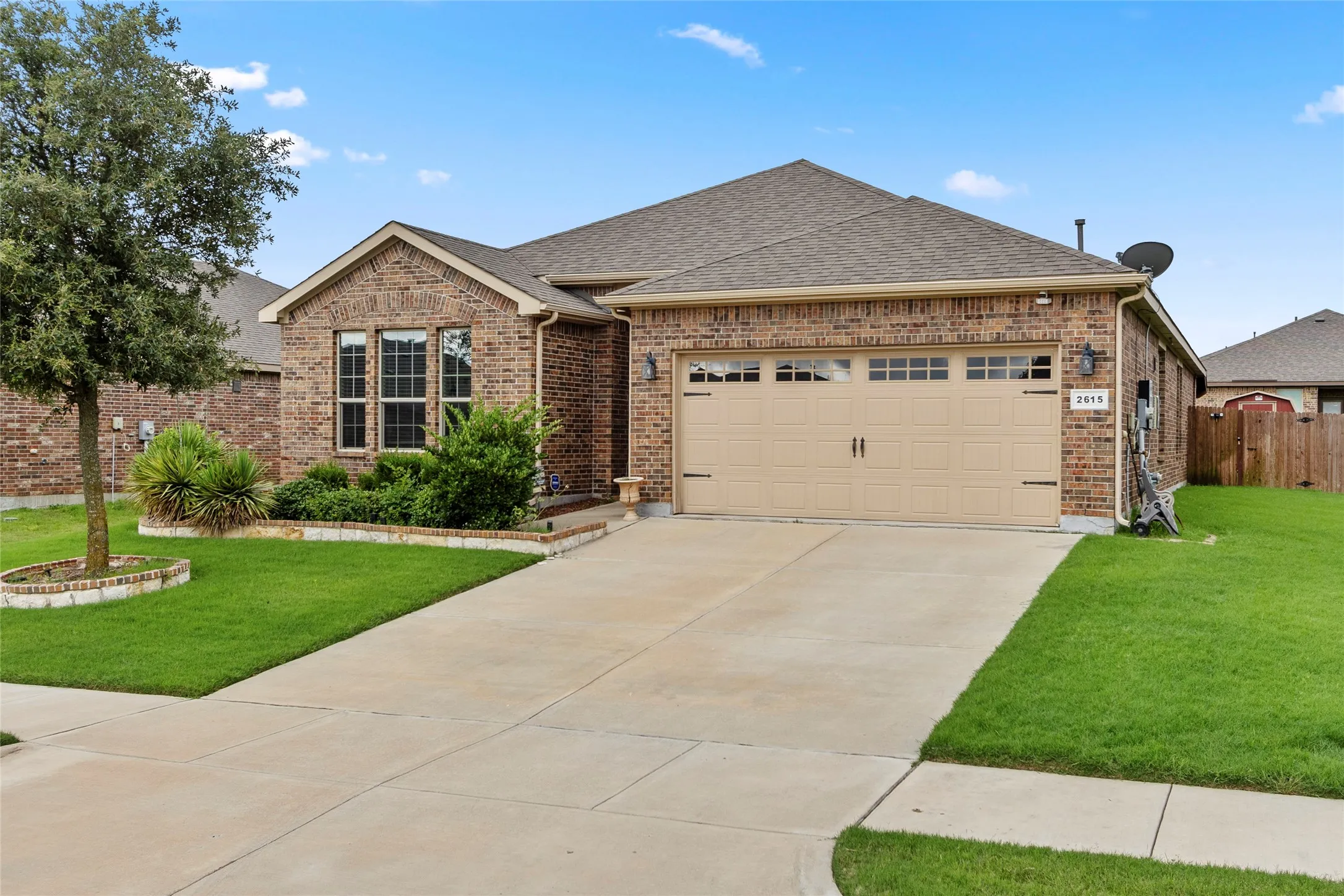 Brick exterior with a peaked roofline, featuring a two-car garage with a paneled door