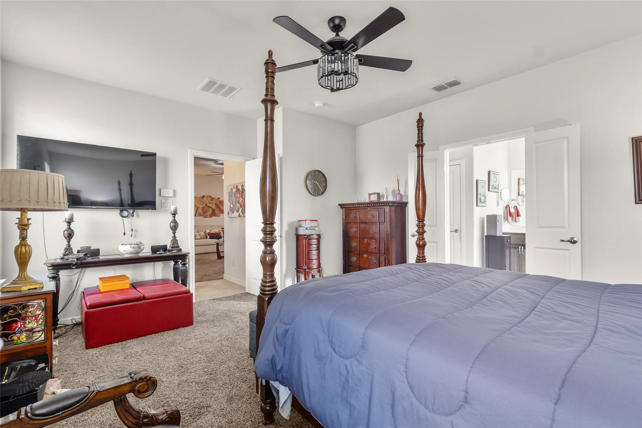 Carpeted room with a black ceiling fan featuring a decorative crystal light fixture