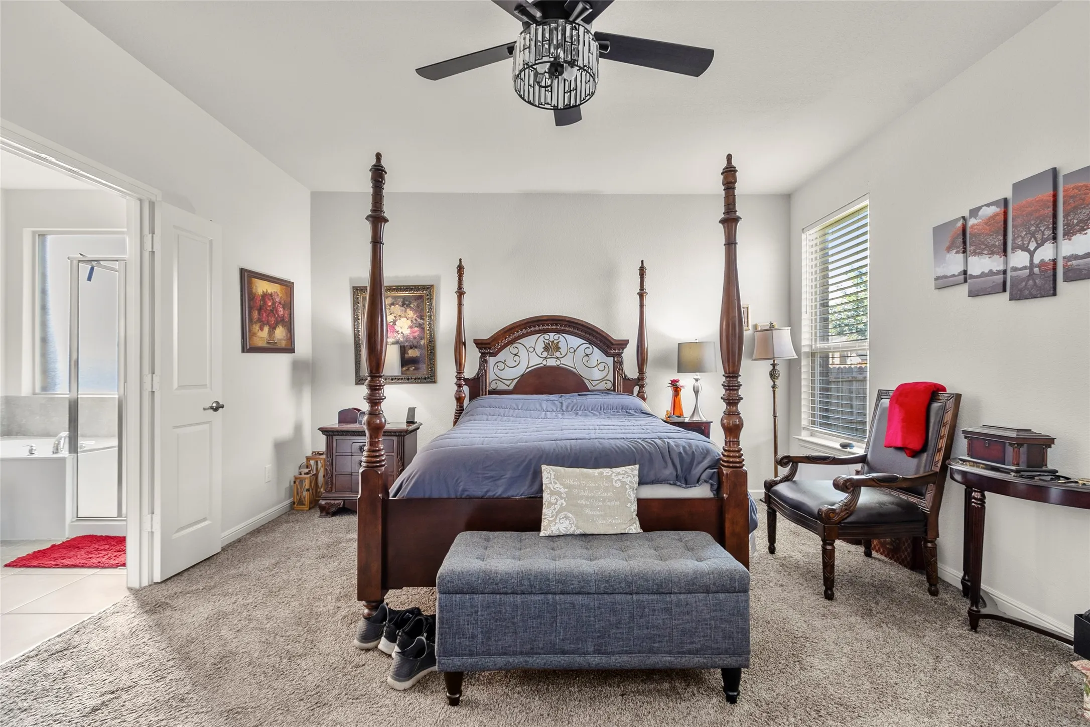 Plush carpeted bedroom with a ceiling fan light fixture