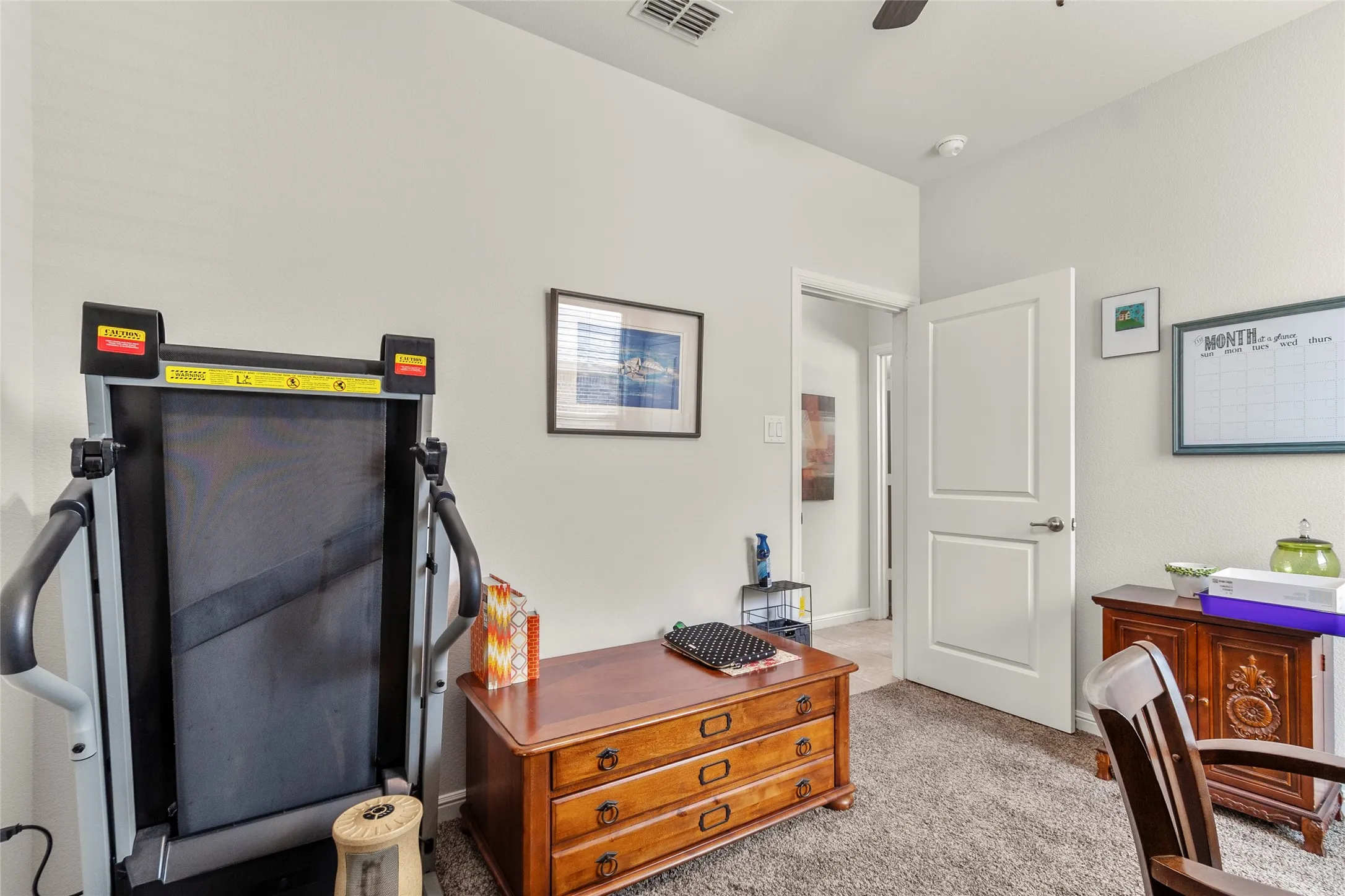 Room featuring light-toned walls, textured carpet flooring, and a white two-panel interior door