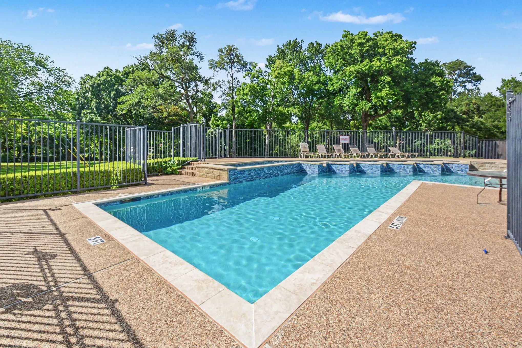 Swimming pool with a textured aggregate deck and light-toned coping