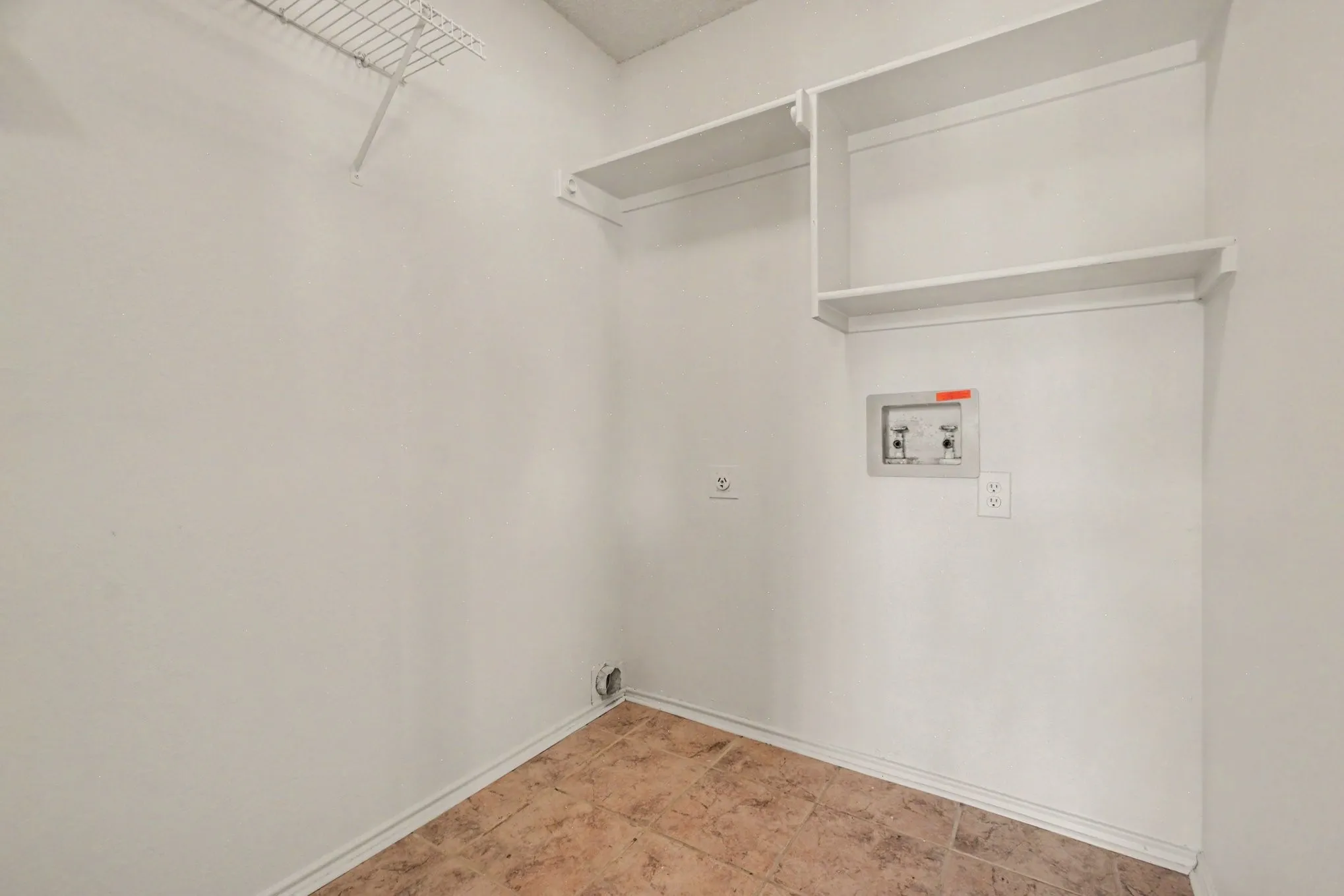 1st floor lovely laundry area featuring tiled flooring, built-in shelving, a wire rack, and utility hookups