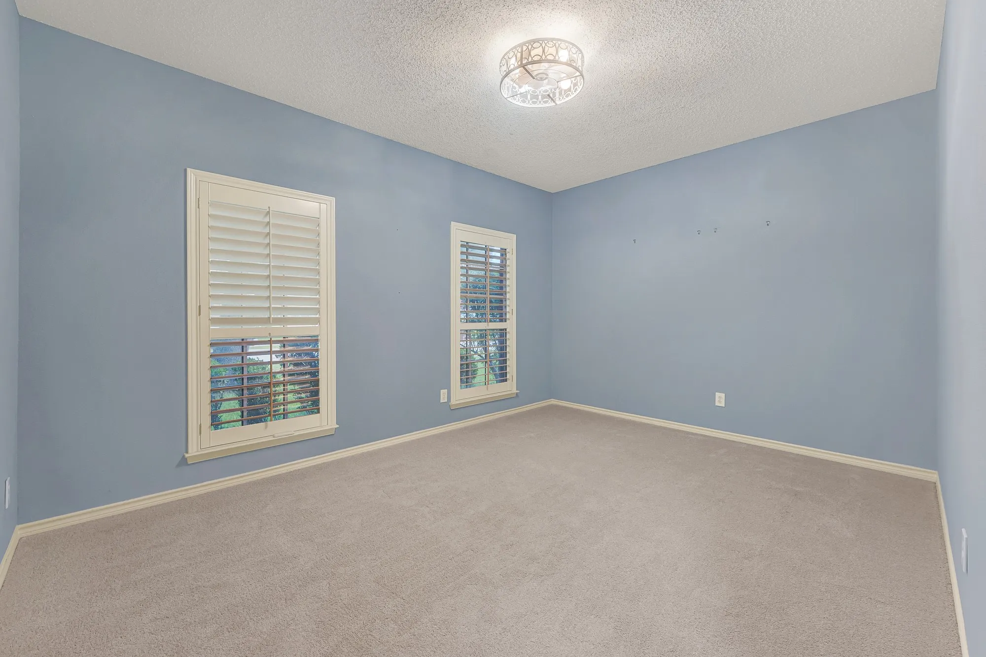 2nd Bedroom Down stairs with plantation shutters.