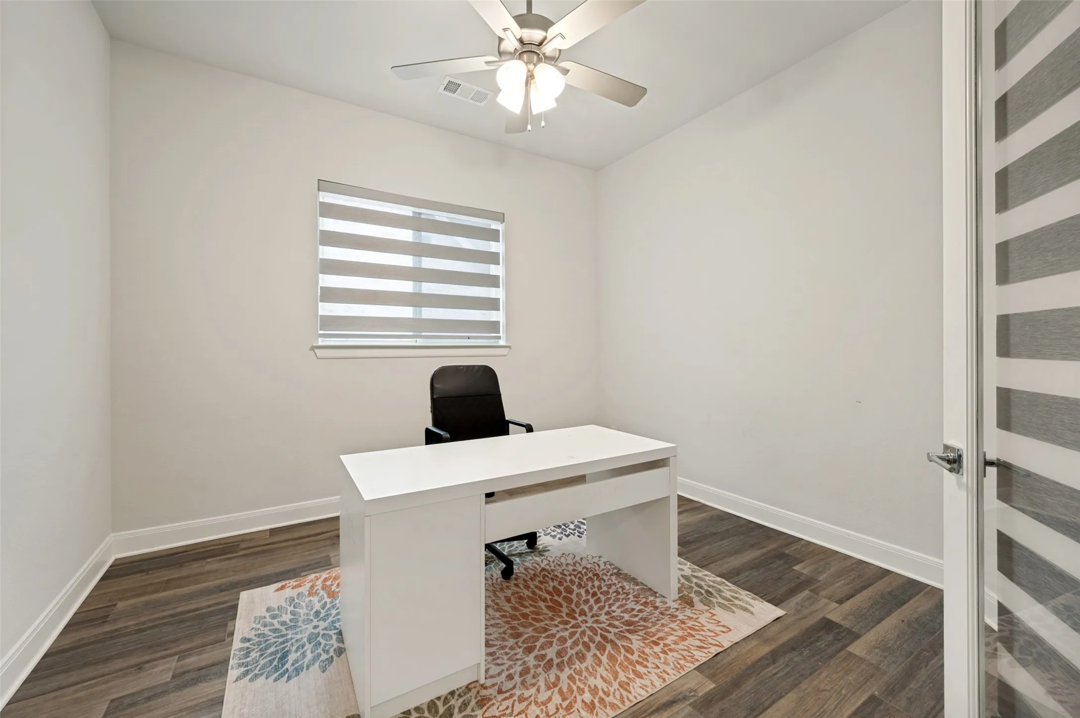 Dedicated room featuring wood-finish flooring and a contemporary ceiling fan