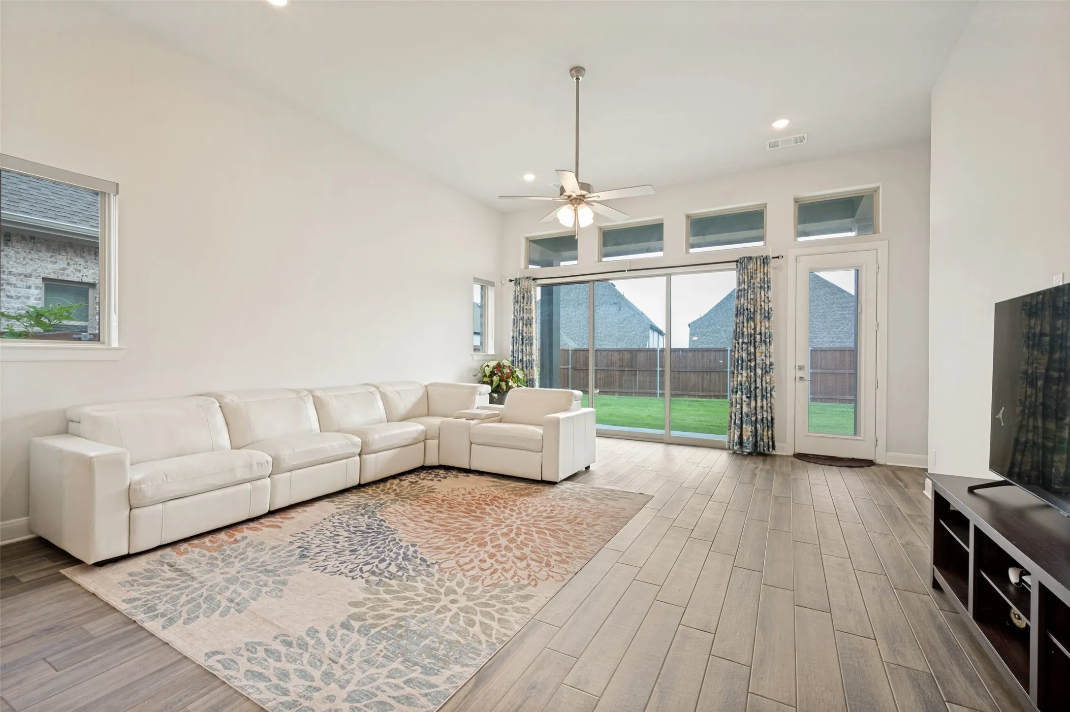Living area with high ceilings, recessed lighting, and wood-finish flooring