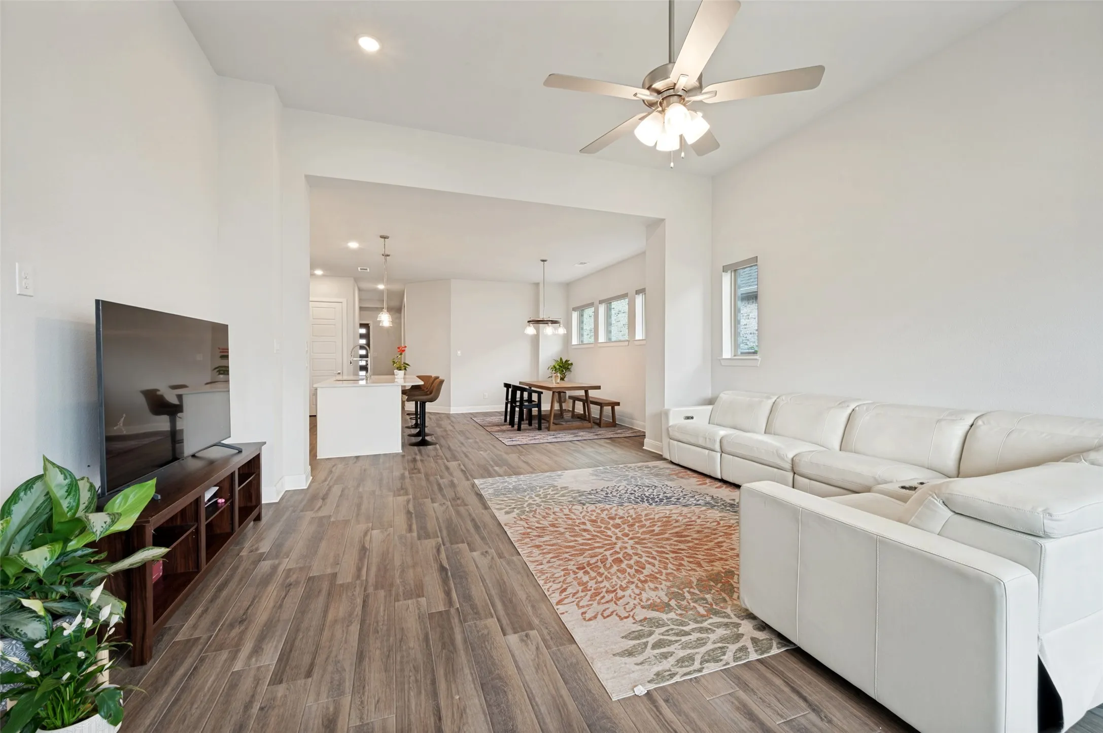 Spacious living area featuring wood-finish flooring, recessed lighting, and a ceiling fan