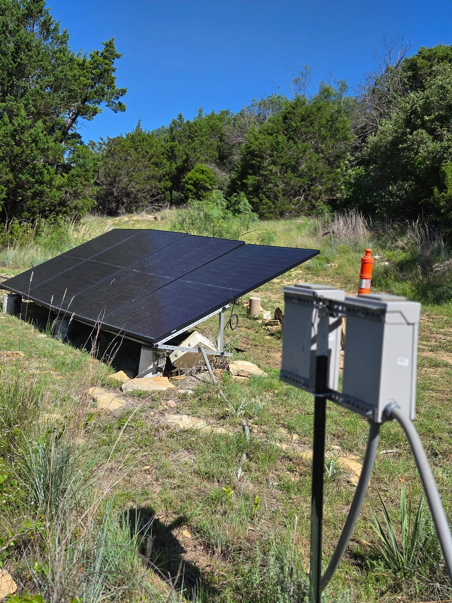Ground-mounted solar panel array featuring multiple dark-paneled modules