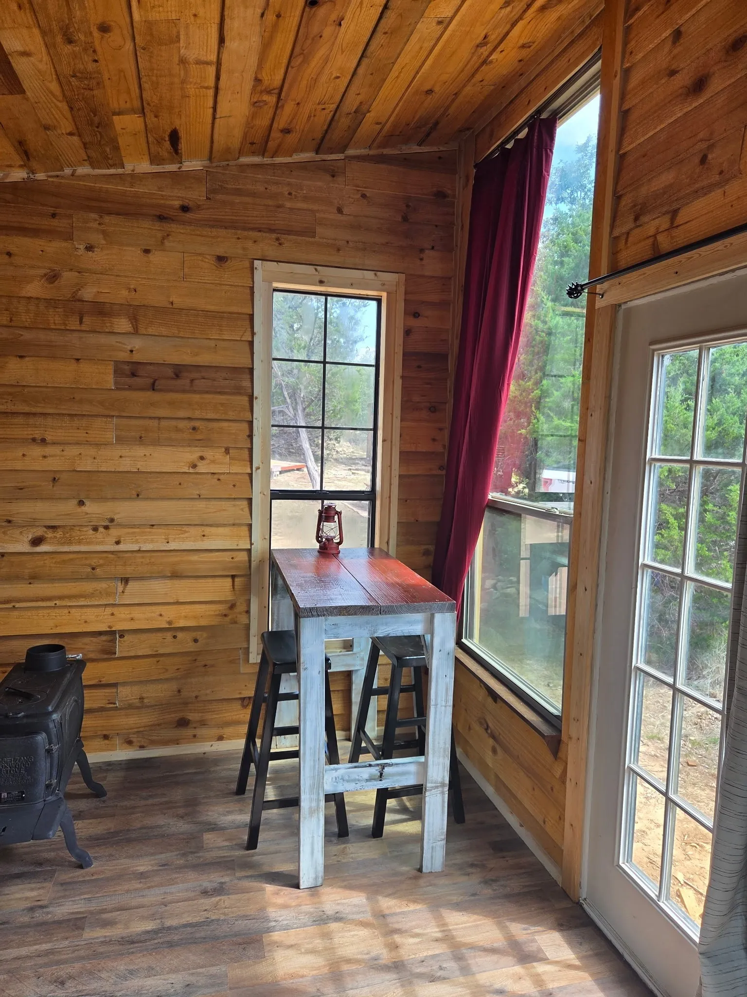 Wood-paneled interior featuring a built-in wood-burning stove and wood-finish flooring