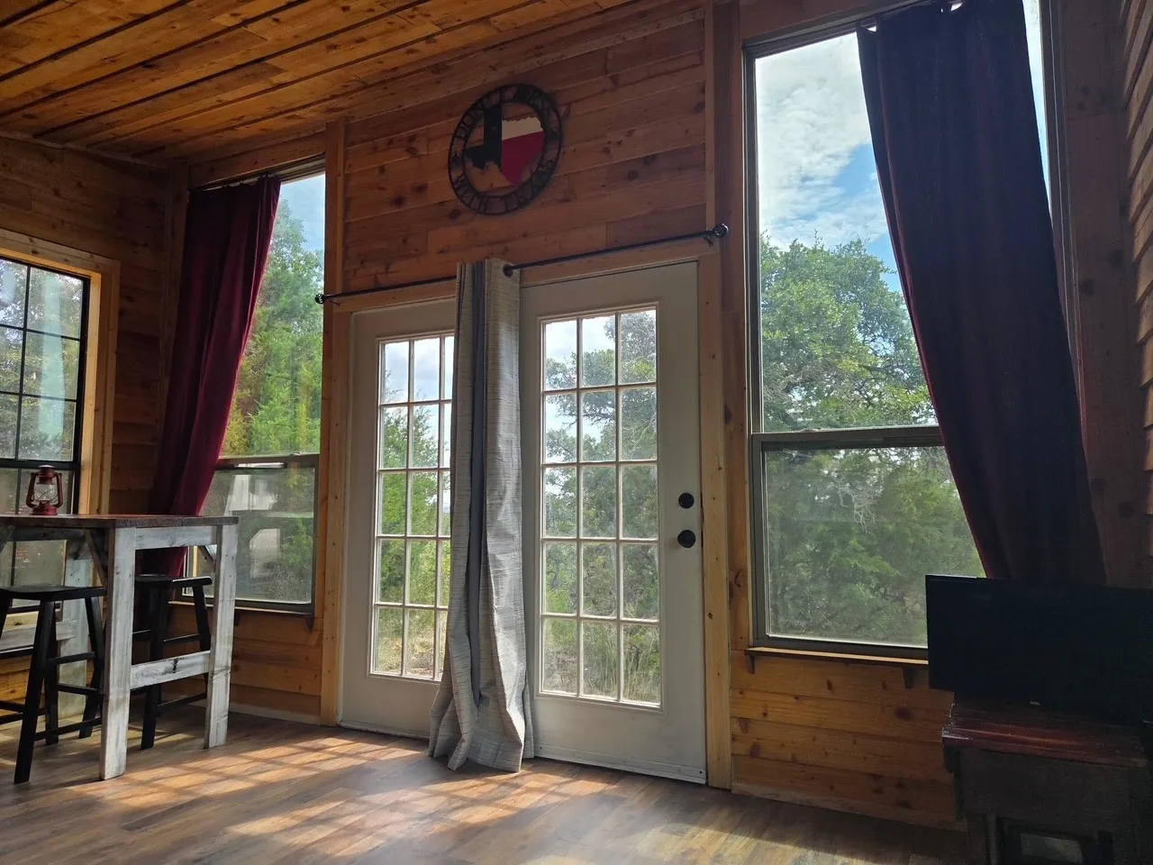 Wood-paneled interior featuring multiple tall windows and glass-paneled double doors