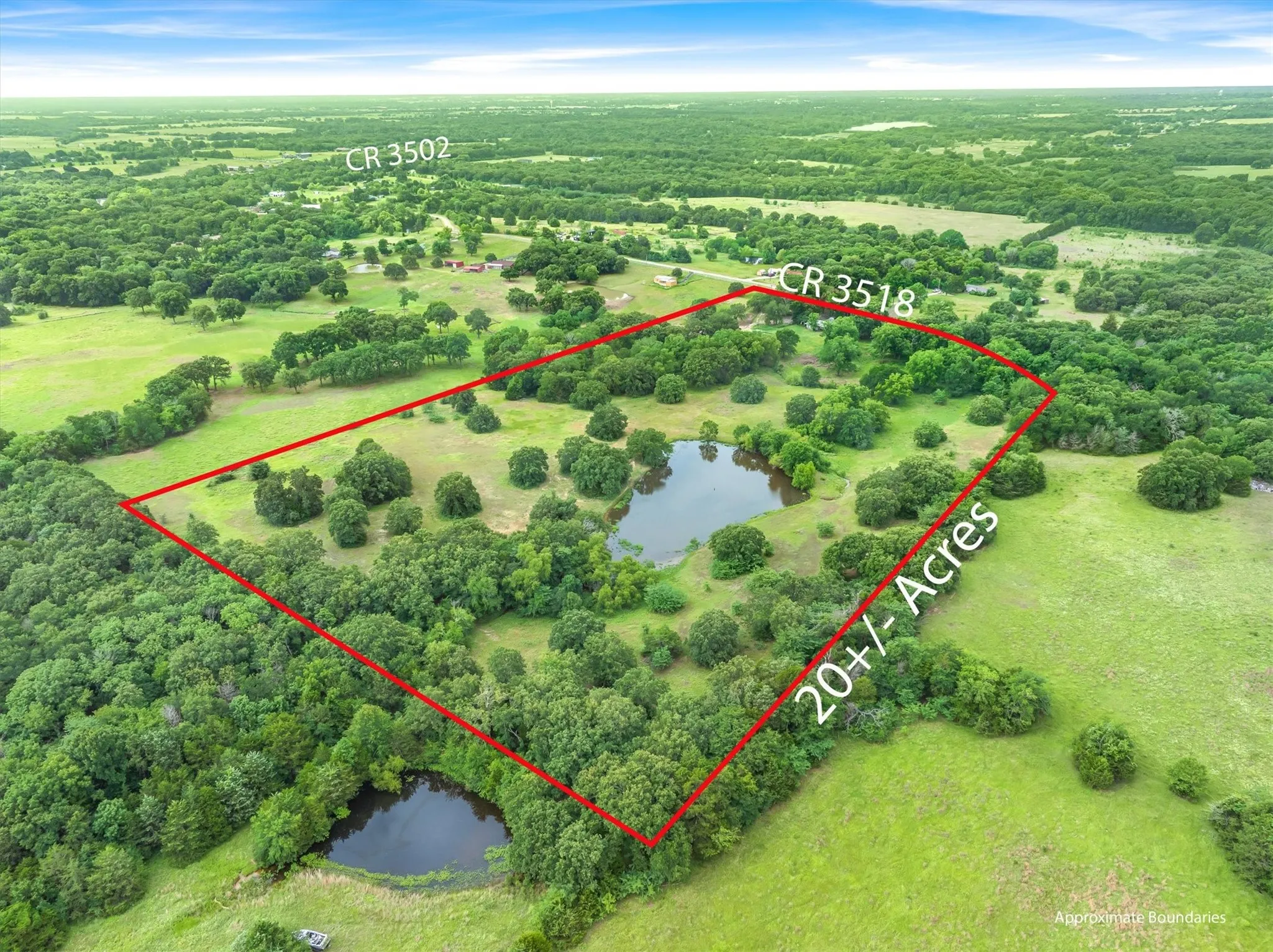 Expansive 20+/- acre lot featuring diverse topography with wooded areas and open green spaces