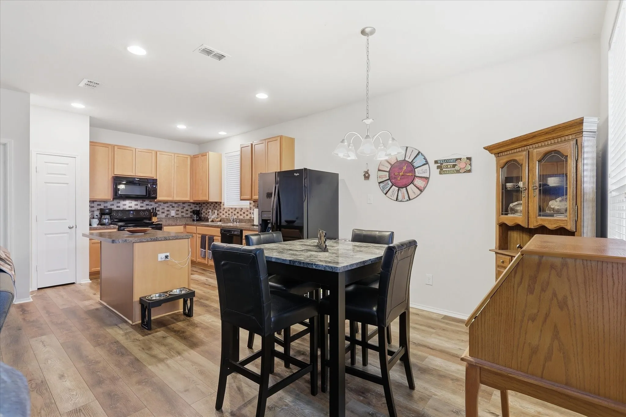 Open-concept dining and kitchen space featuring wood-finish flooring