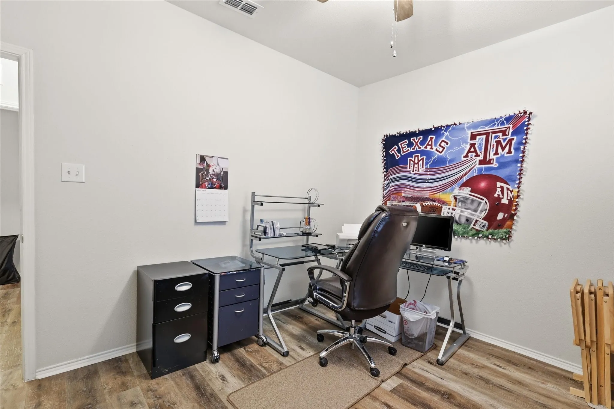 Room featuring wood-finish flooring, white baseboards, and light neutral wall paint