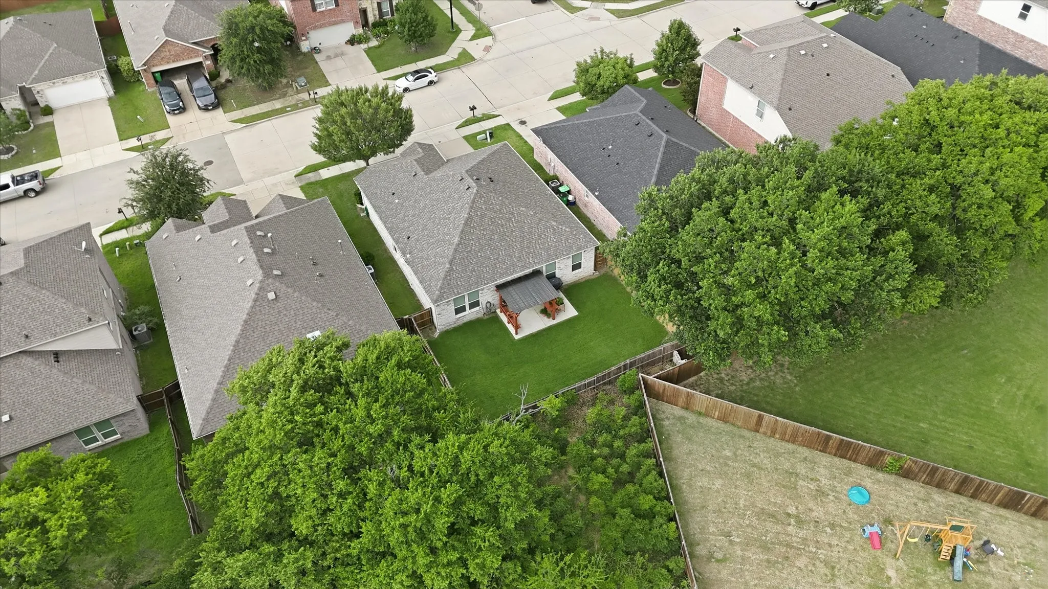 Aerial perspective highlighting the property's expansive green lawn and surrounding trees
