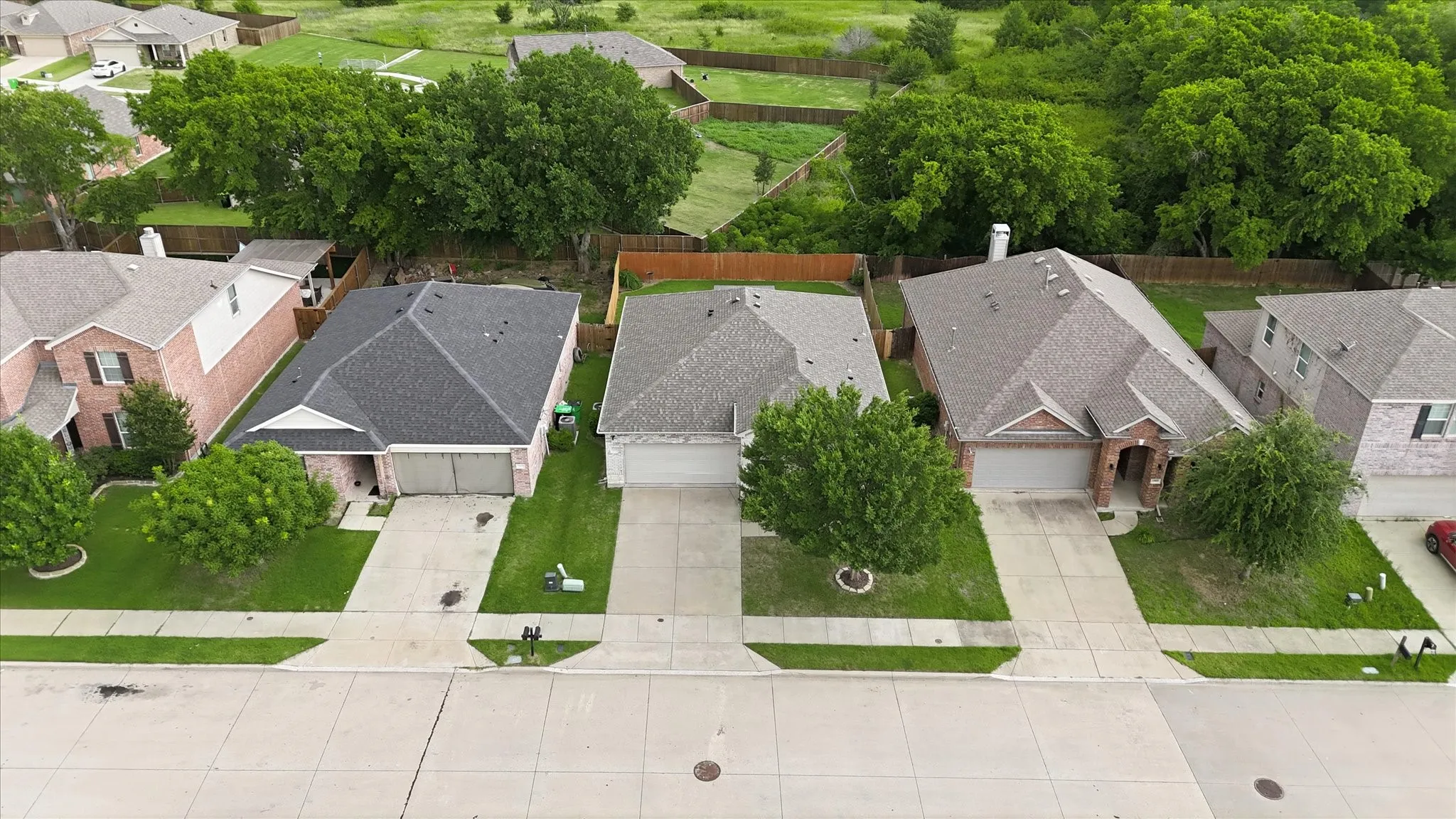 Property featuring a paved driveway, attached two-car garage, and a gabled roof