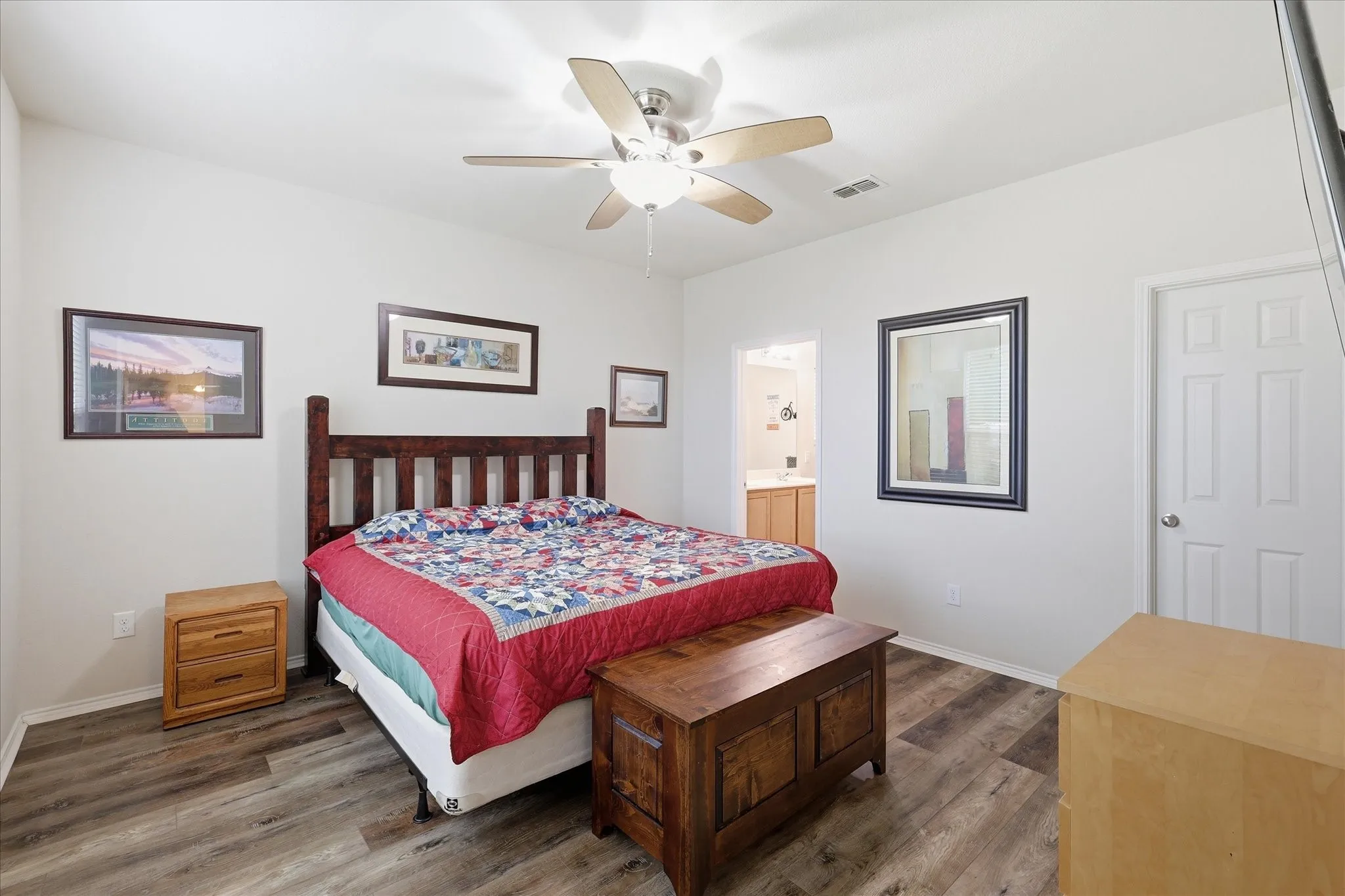 Bedroom featuring wood-finish flooring, a ceiling fan with integrated lighting, and a paneled interior door