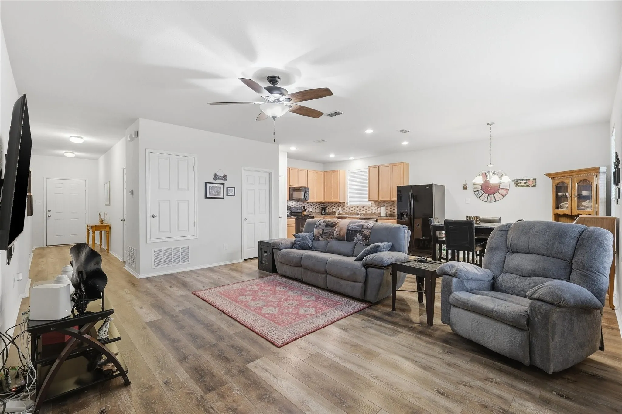 Open-concept living area featuring wood-finish flooring, recessed lighting, and a ceiling fan