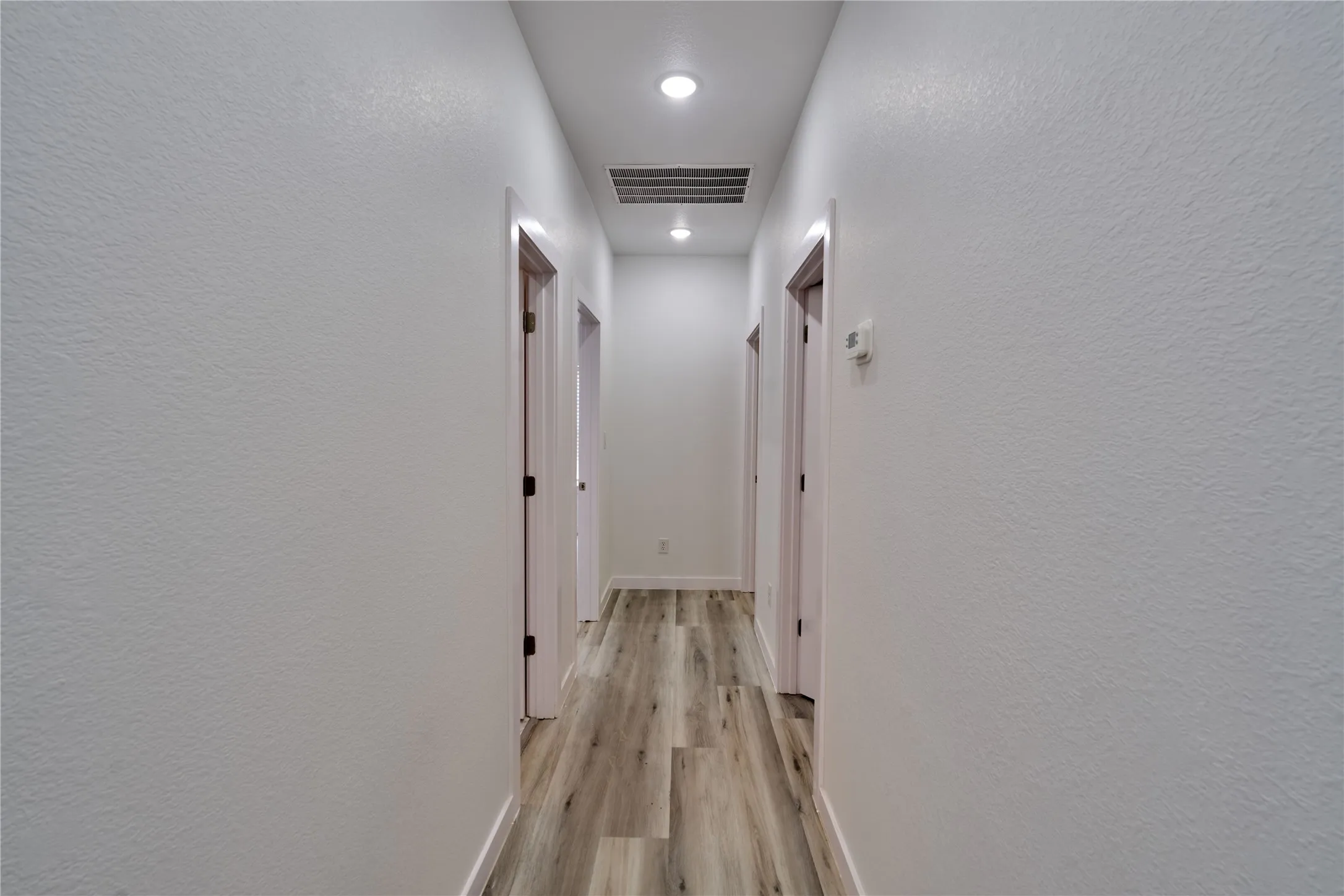 Hallway featuring wood-finish flooring and recessed lighting