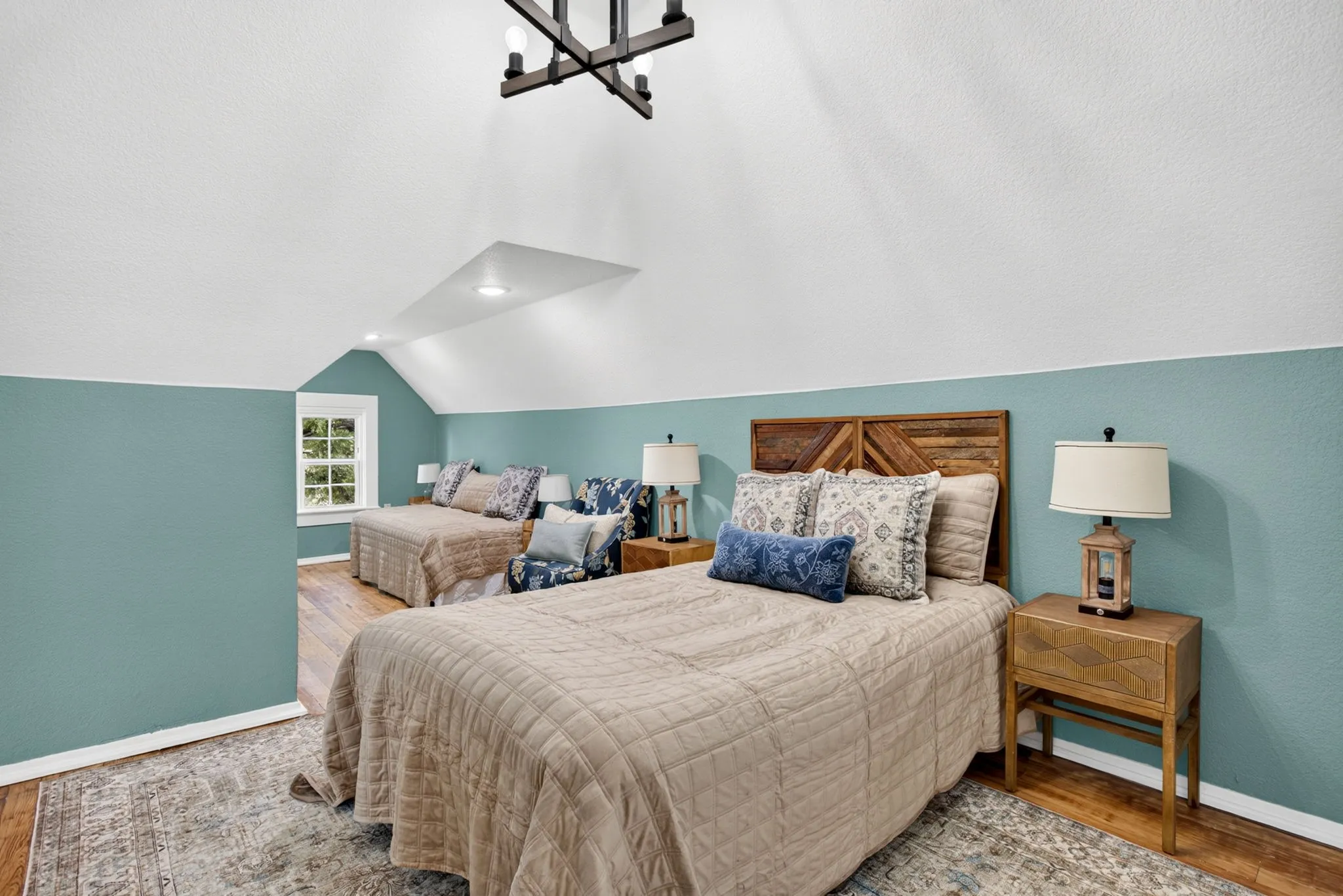 Spacious room featuring sloped ceilings, recessed lighting, and wood-finish flooring