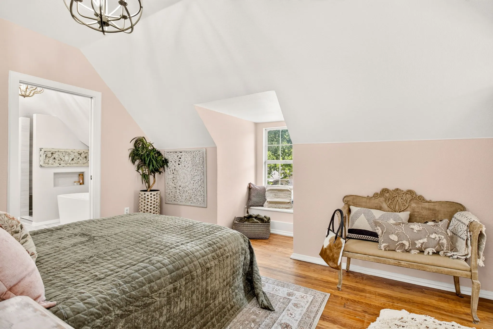 Attic space featuring wood-finish flooring, an arched doorway, and built-in window seating