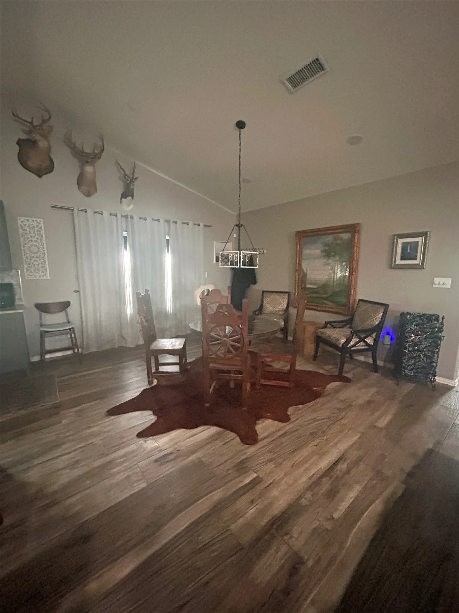 Vaulted ceiling with a contemporary chandelier, wood-finish flooring, and recessed lighting