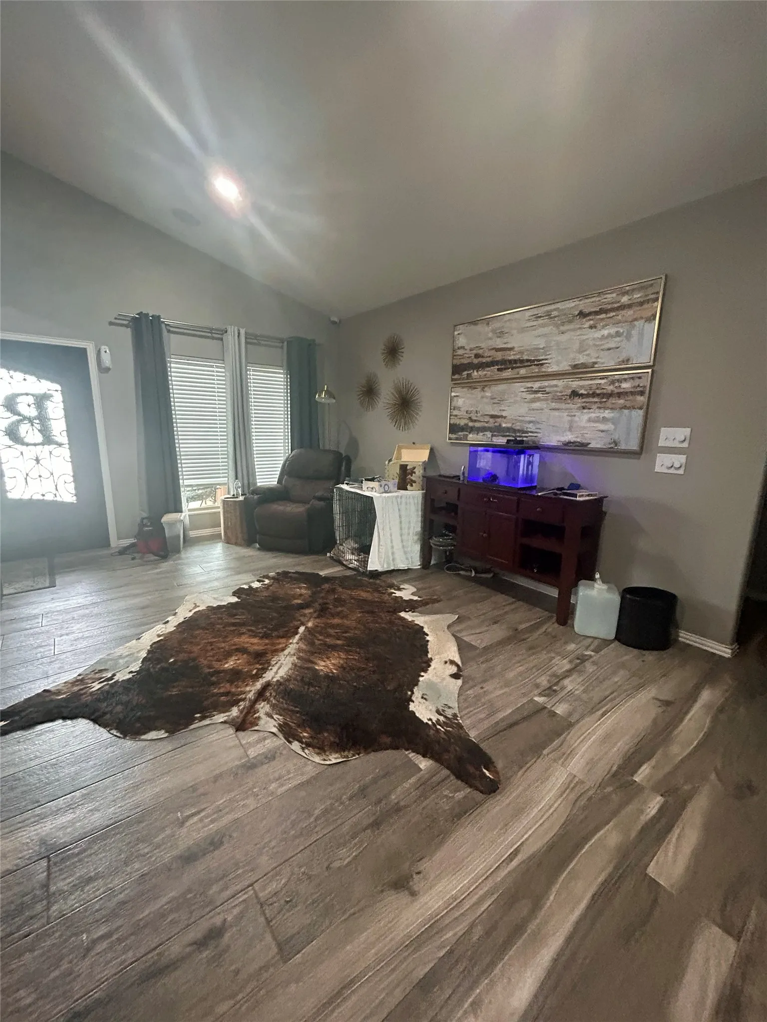Spacious interior featuring wood-finish flooring, vaulted ceilings, and neutral wall tones