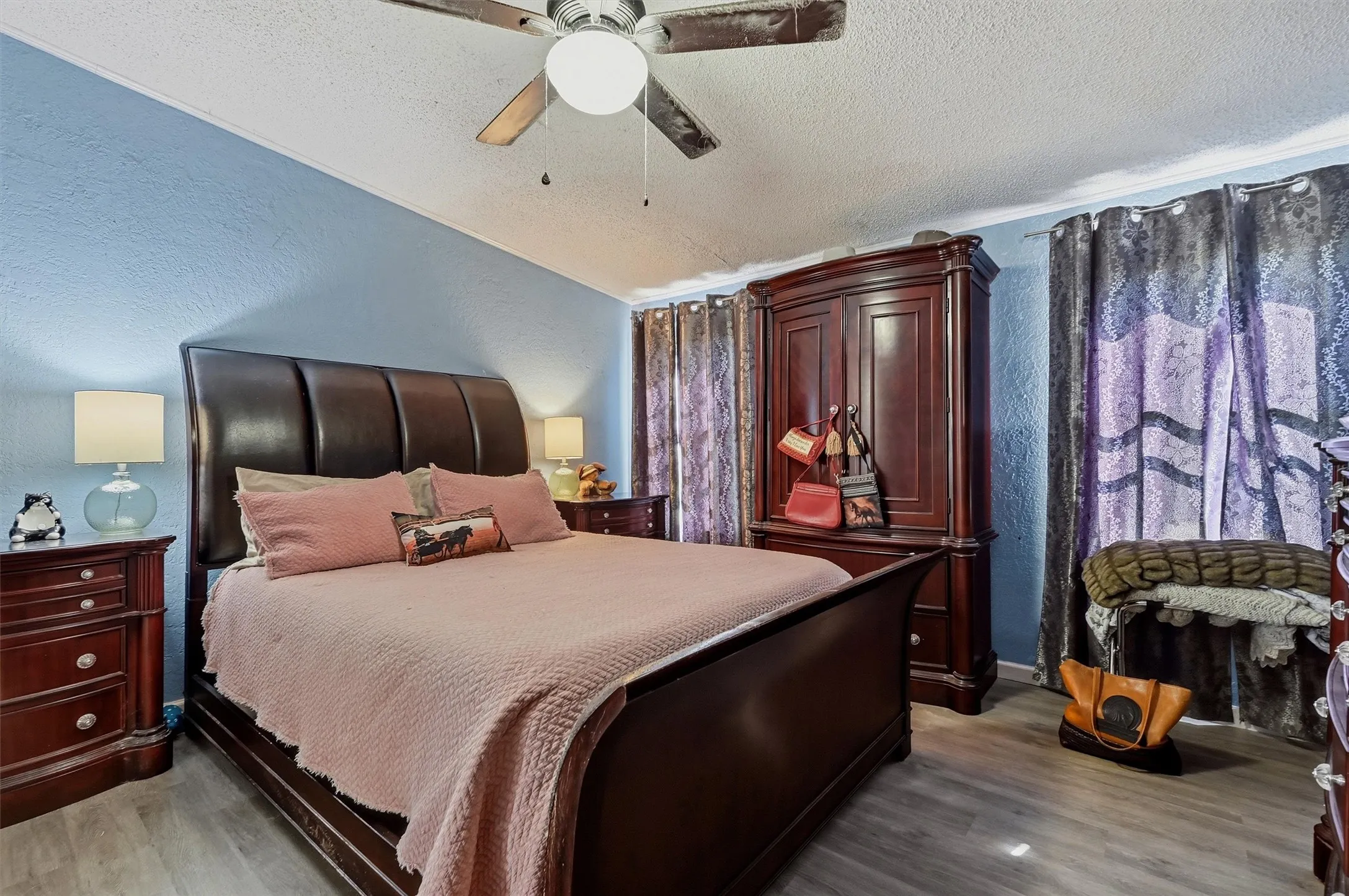 Room featuring blue textured walls and wood-finish flooring