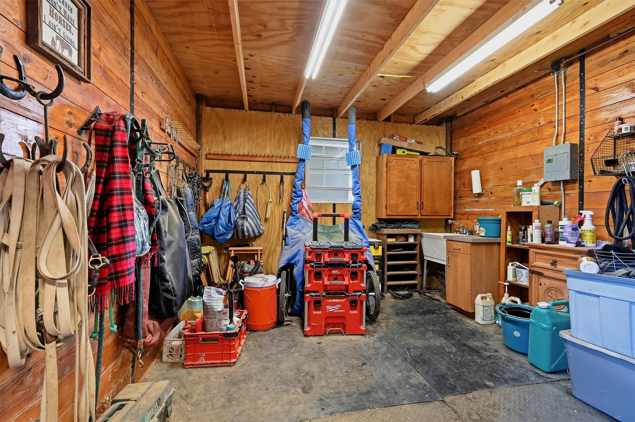 Utility room with wood plank walls and exposed wood ceiling beams