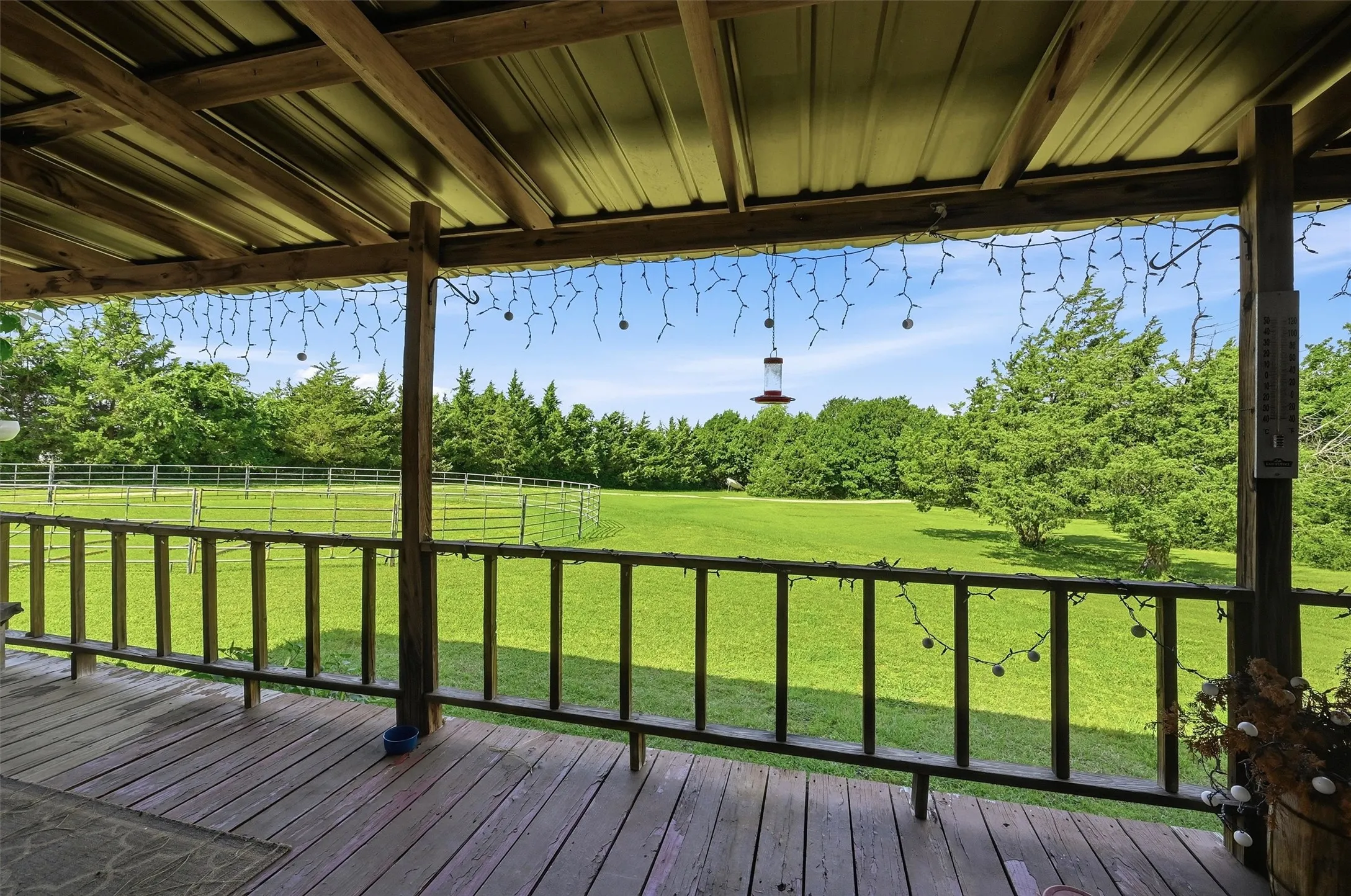 Covered porch featuring a wood-finish floor and wooden railing