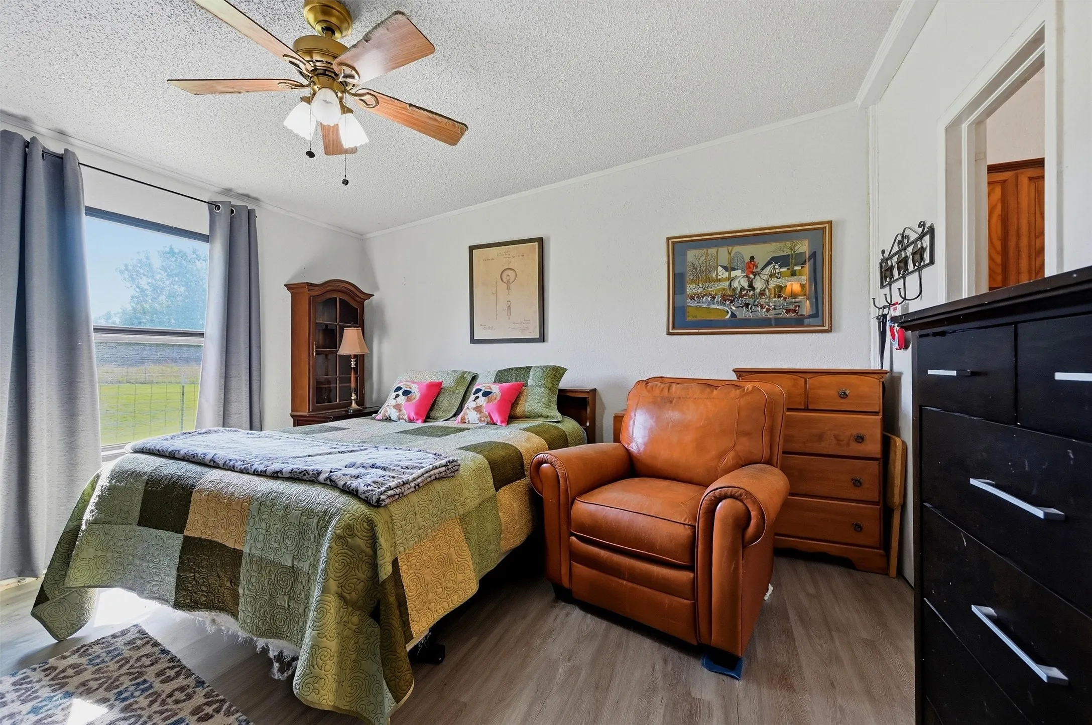 Bedroom featuring light wood-finish flooring, white walls, and a window