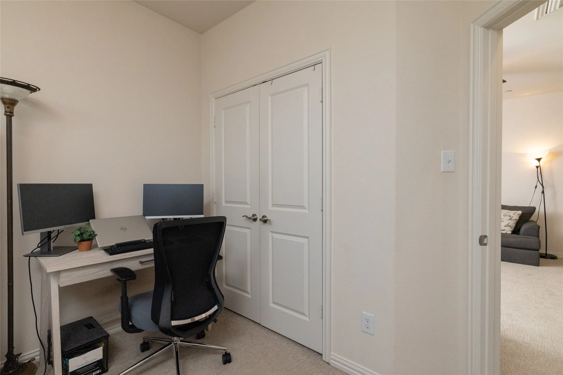 Neutral-toned walls enhance the bright ambiance of this room, featuring light-colored carpeting and white trim