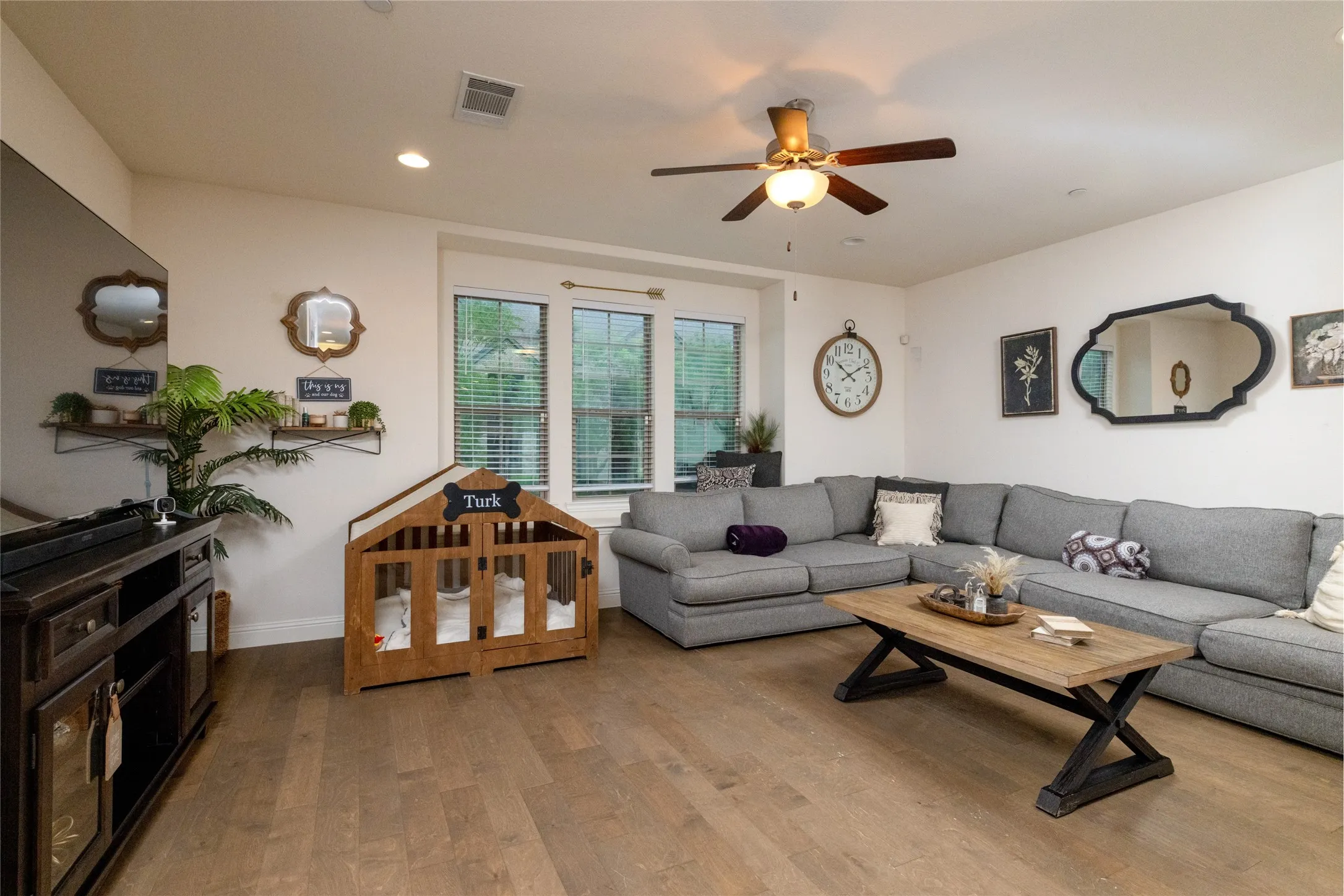 Spacious living area featuring wood-finish flooring, recessed lighting, and a ceiling fan.