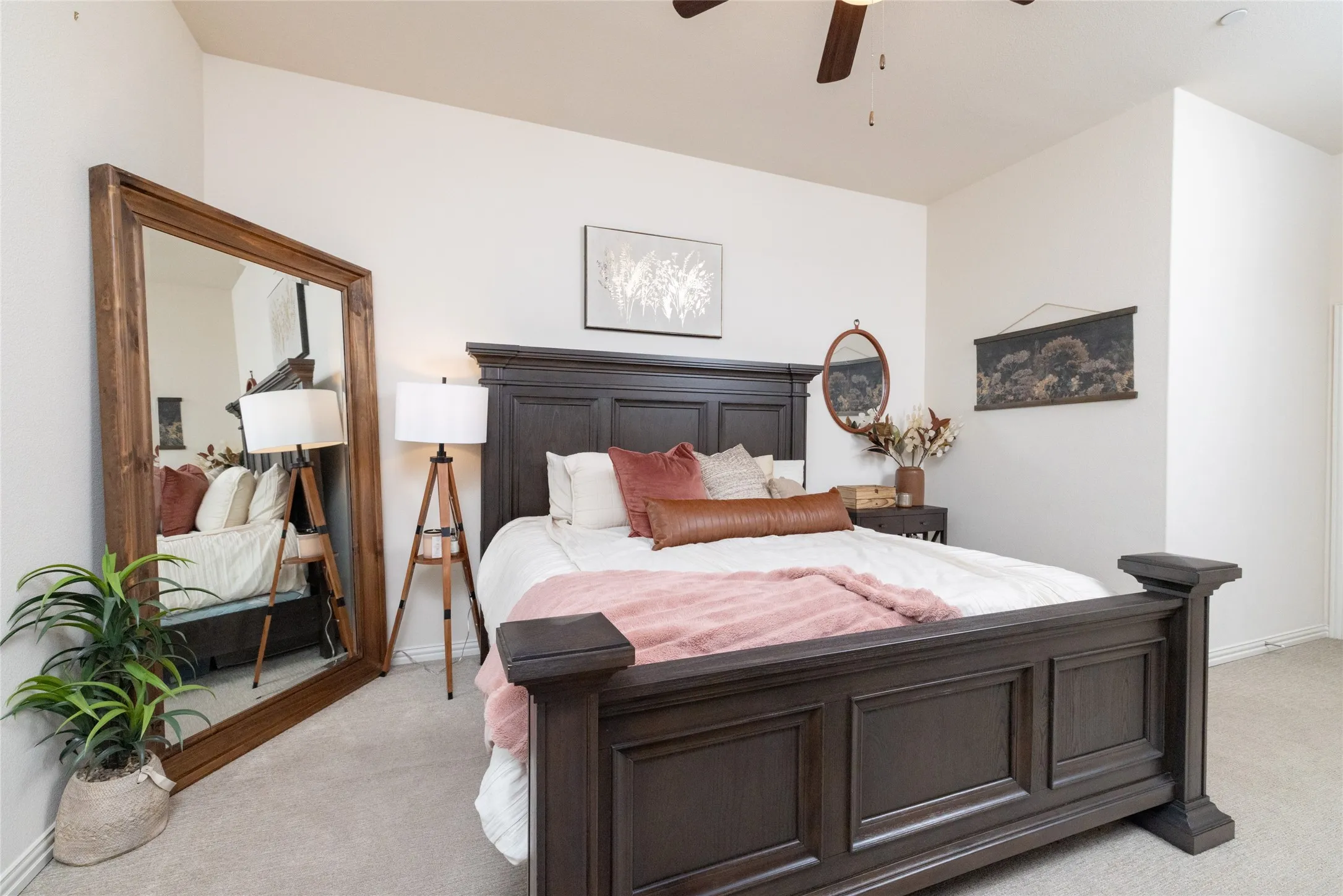 Carpeted bedroom featuring a dark wood-finish bed frame, high ceilings, and a ceiling fan