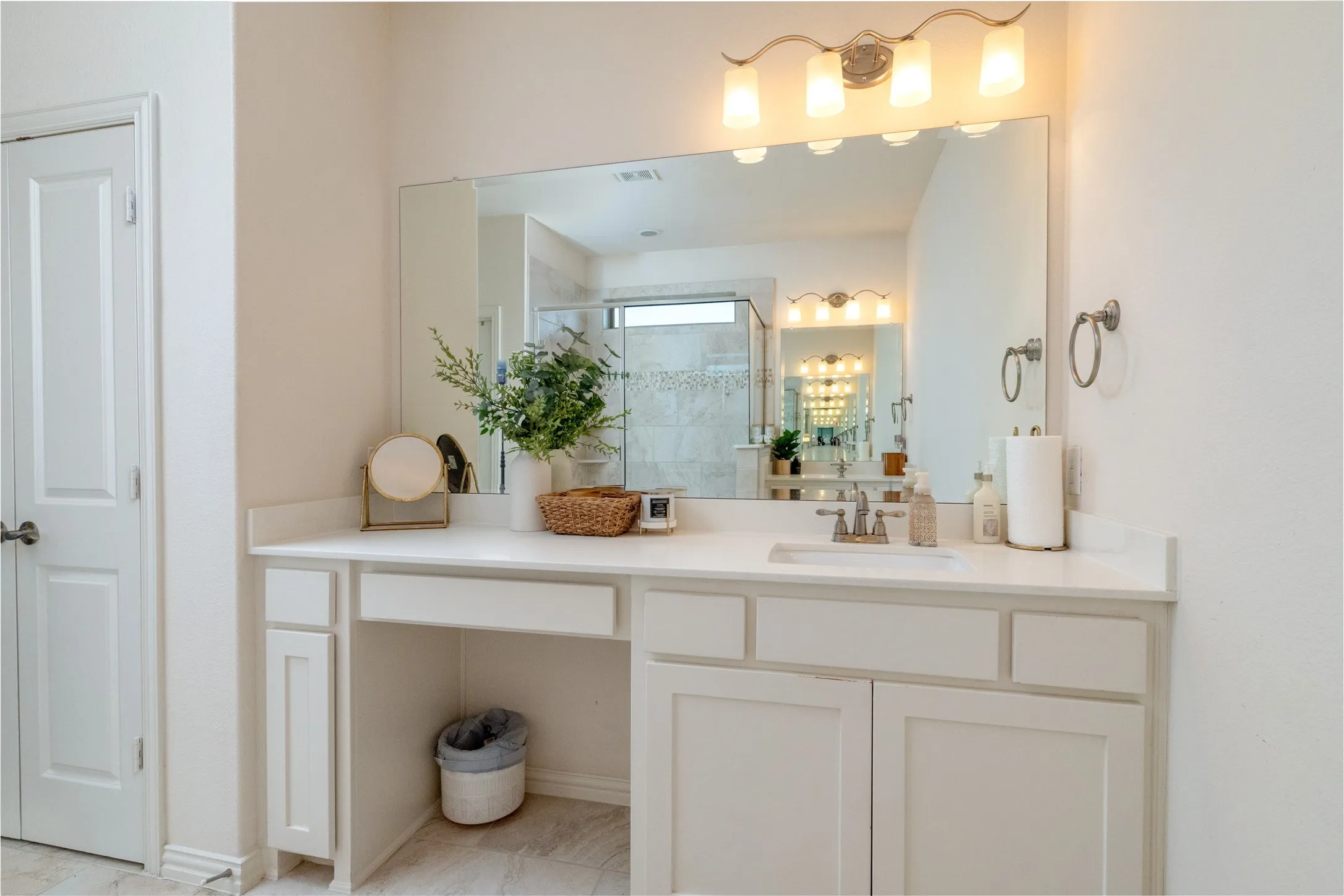 Vanity area featuring a quartz countertop, integrated sink, and an expansive mirror