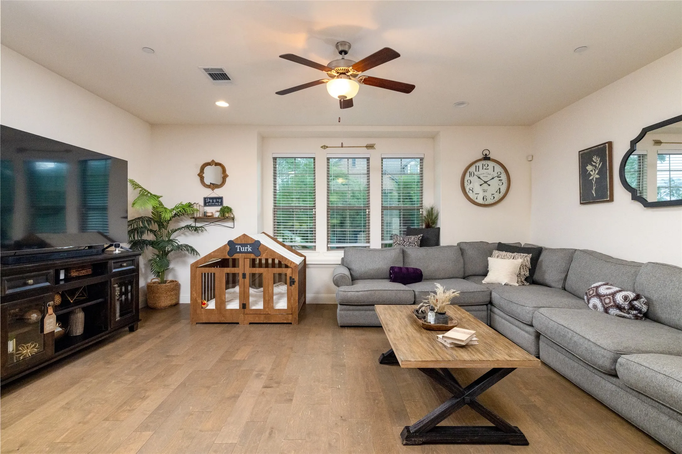 Spacious living area featuring wood-finish flooring, recessed lighting, and a ceiling fan.