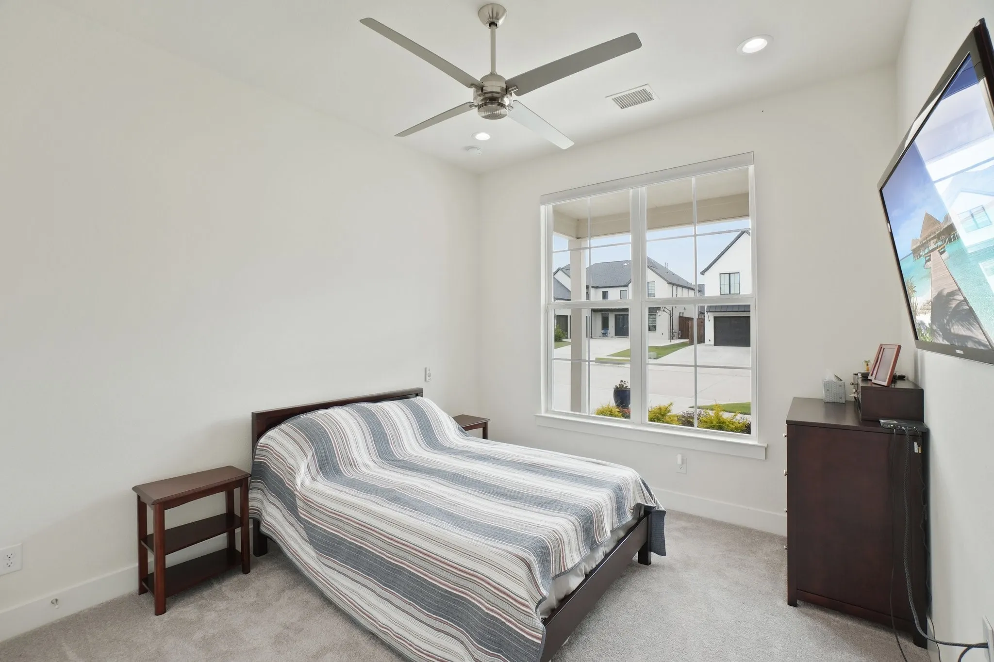 Bright room featuring a large window, recessed lighting, and a ceiling fan