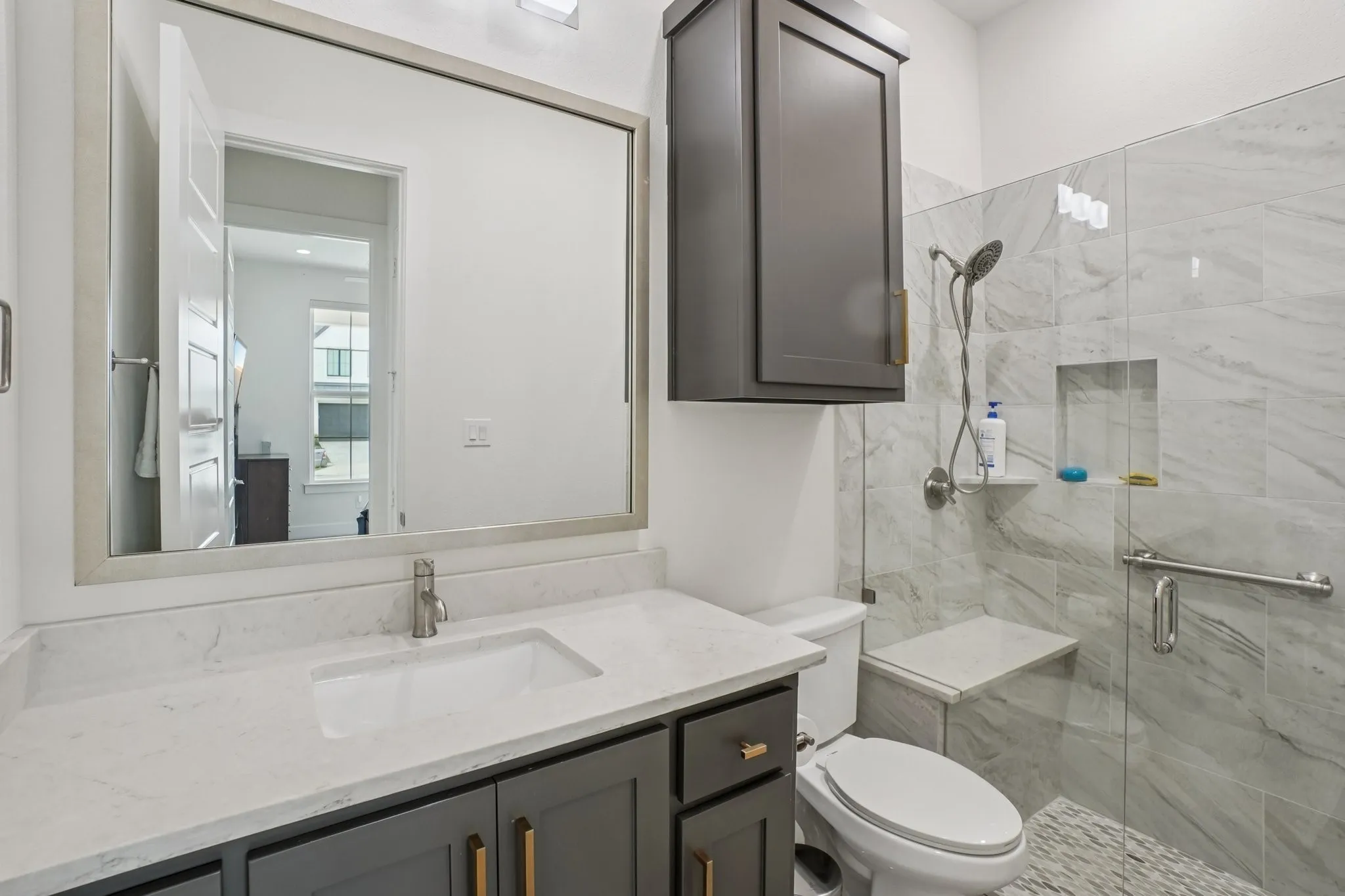 Bathroom featuring a gray vanity with a white countertop, a rectangular sink, and a framed mirror