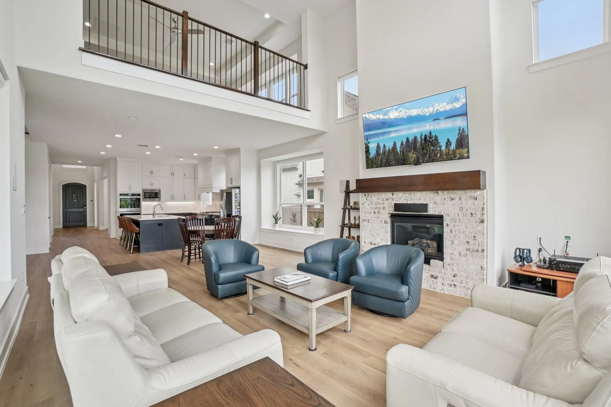 Open-concept living area with soaring ceilings and light wood-finish flooring