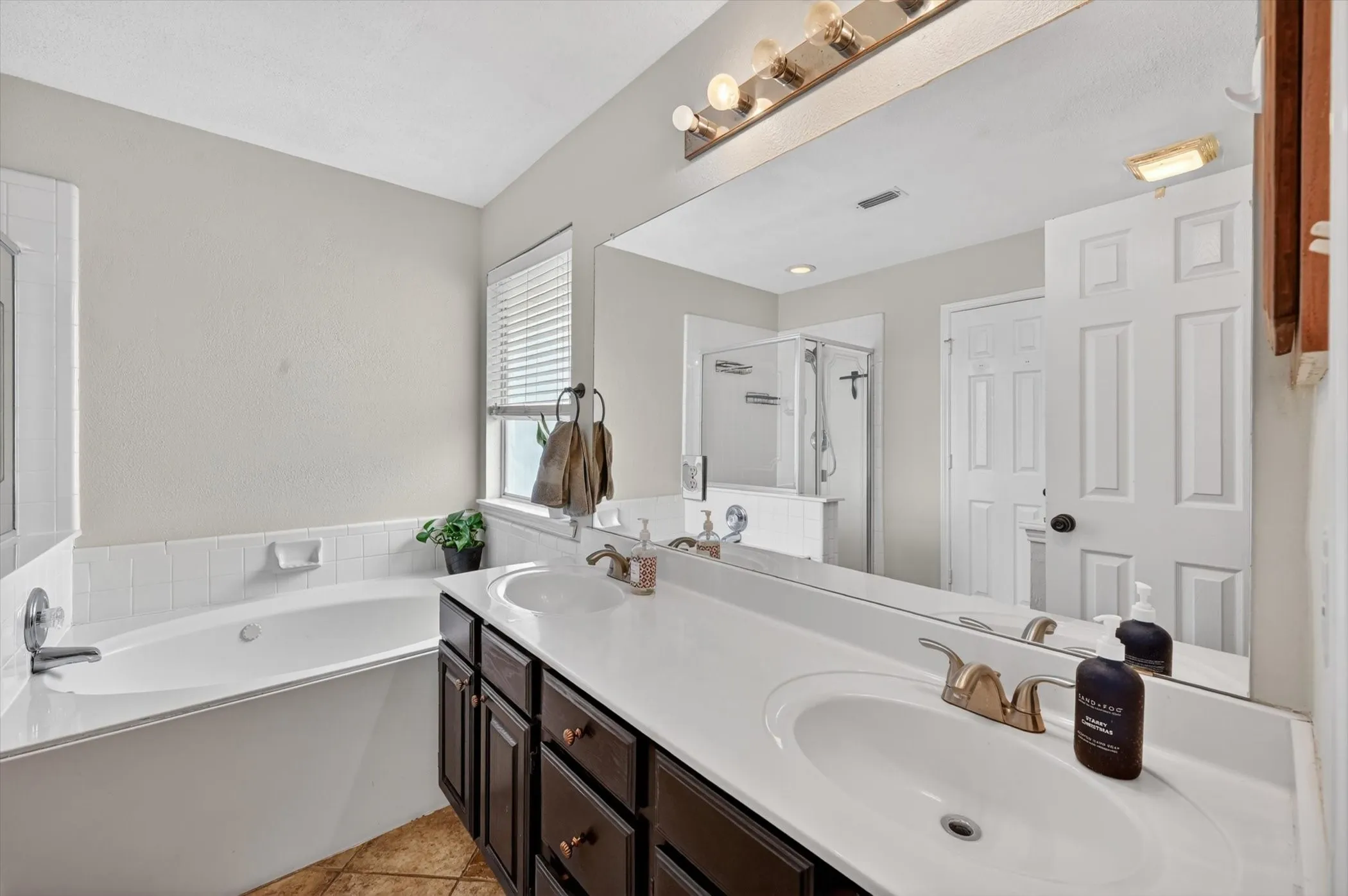 Dual vanity with dark wood-finish cabinetry, white countertops, and undermount sinks