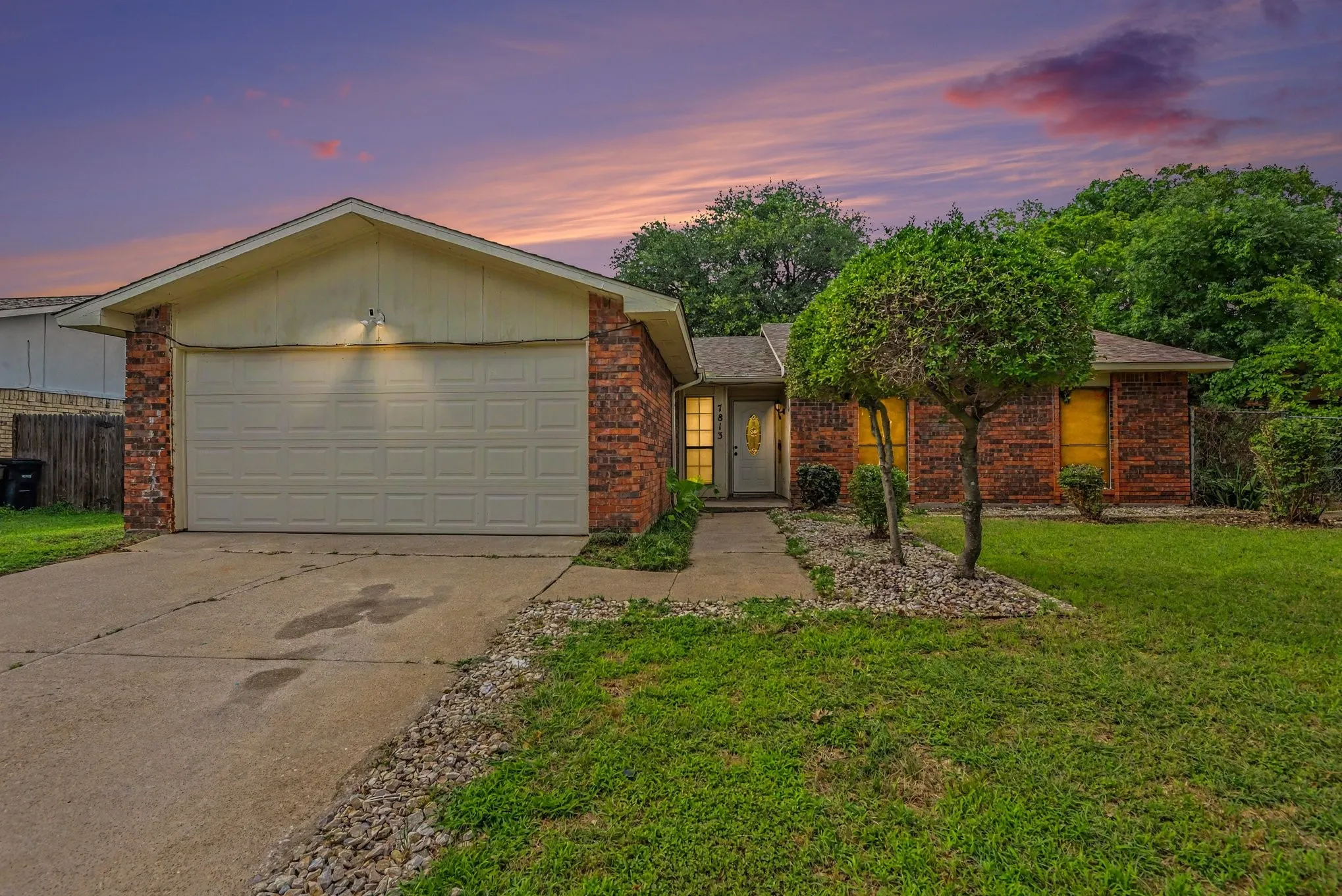 Brick exterior home featuring a two-car garage, concrete driveway, and a welcoming front walkway