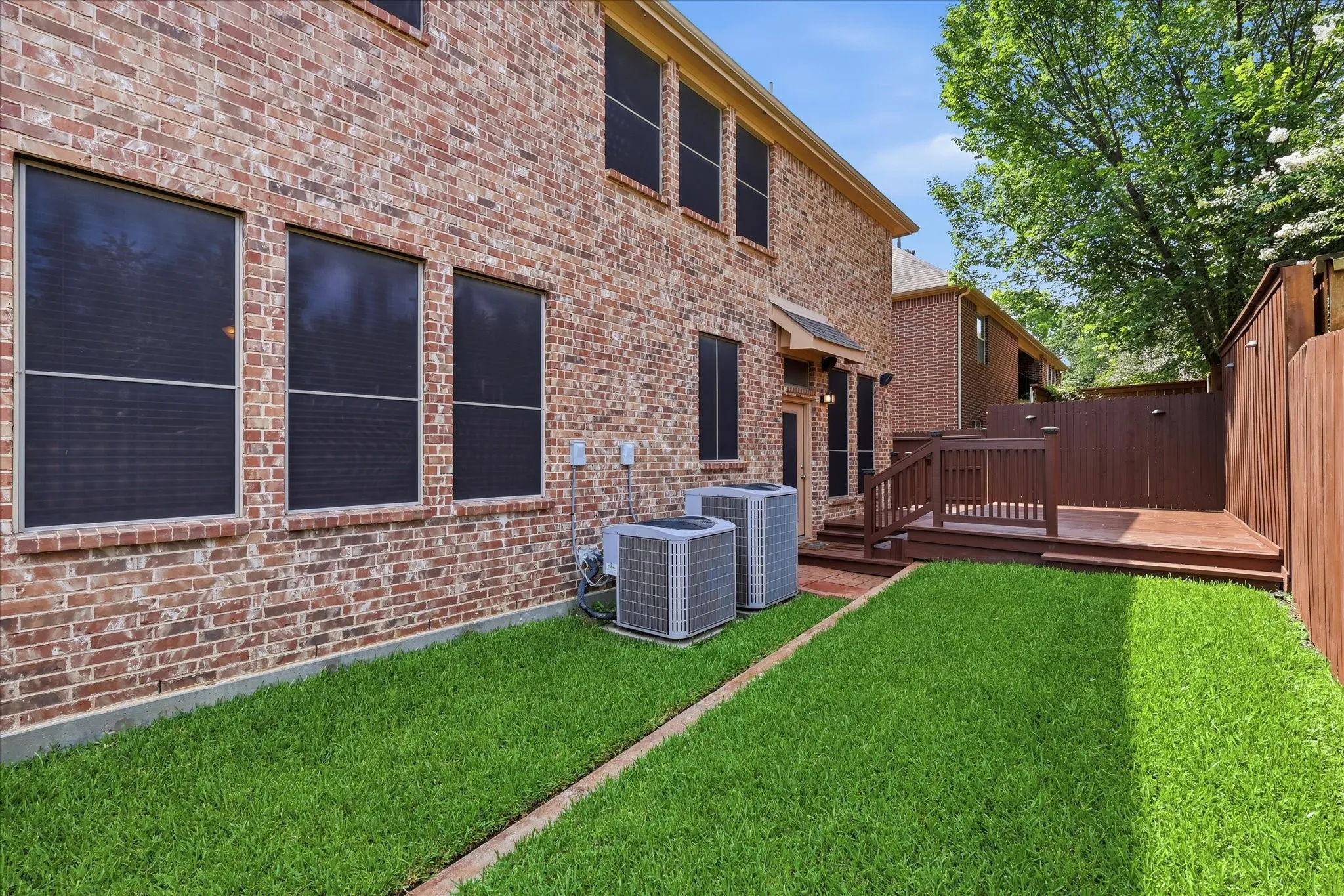 Low maintenance yard features lush St. Augistine grass.