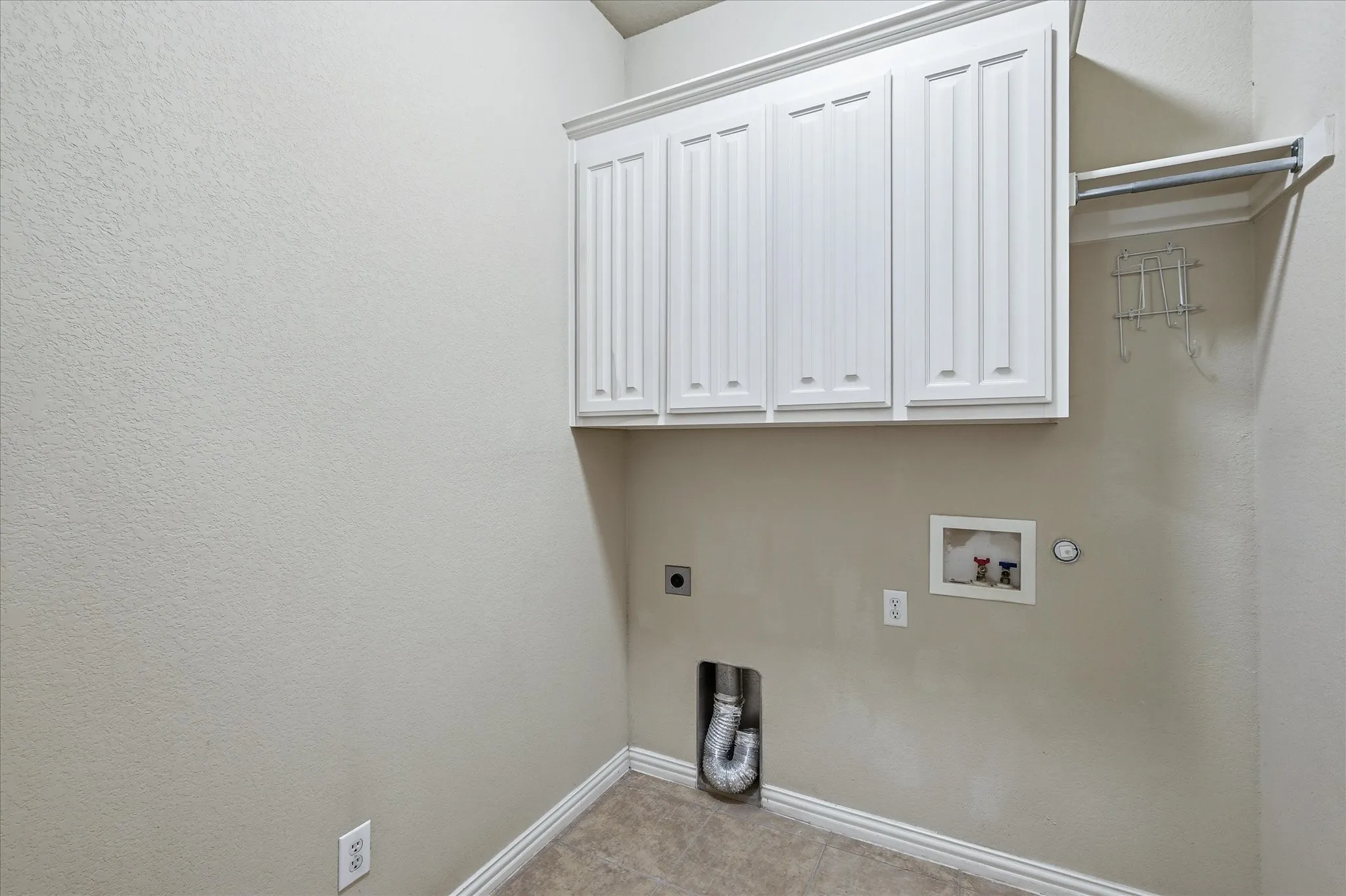 The Laundry Room features built-in cabinetry and a clothing rod with shelf.